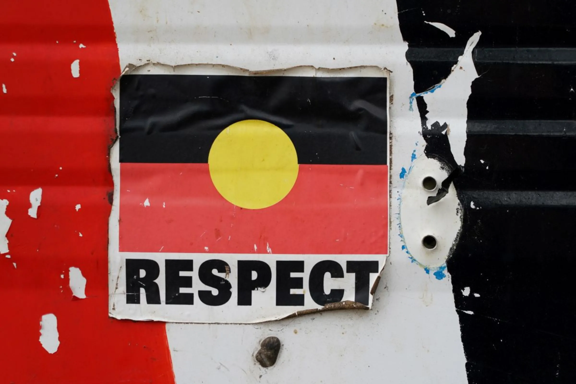 A sticker of the Australian Aboriginal Flag along with the word 'RESPECT' is pictured on a structure at the Aboriginal Tent Embassy, a site of protest since 1972.  REUTERS/Loren Elliott