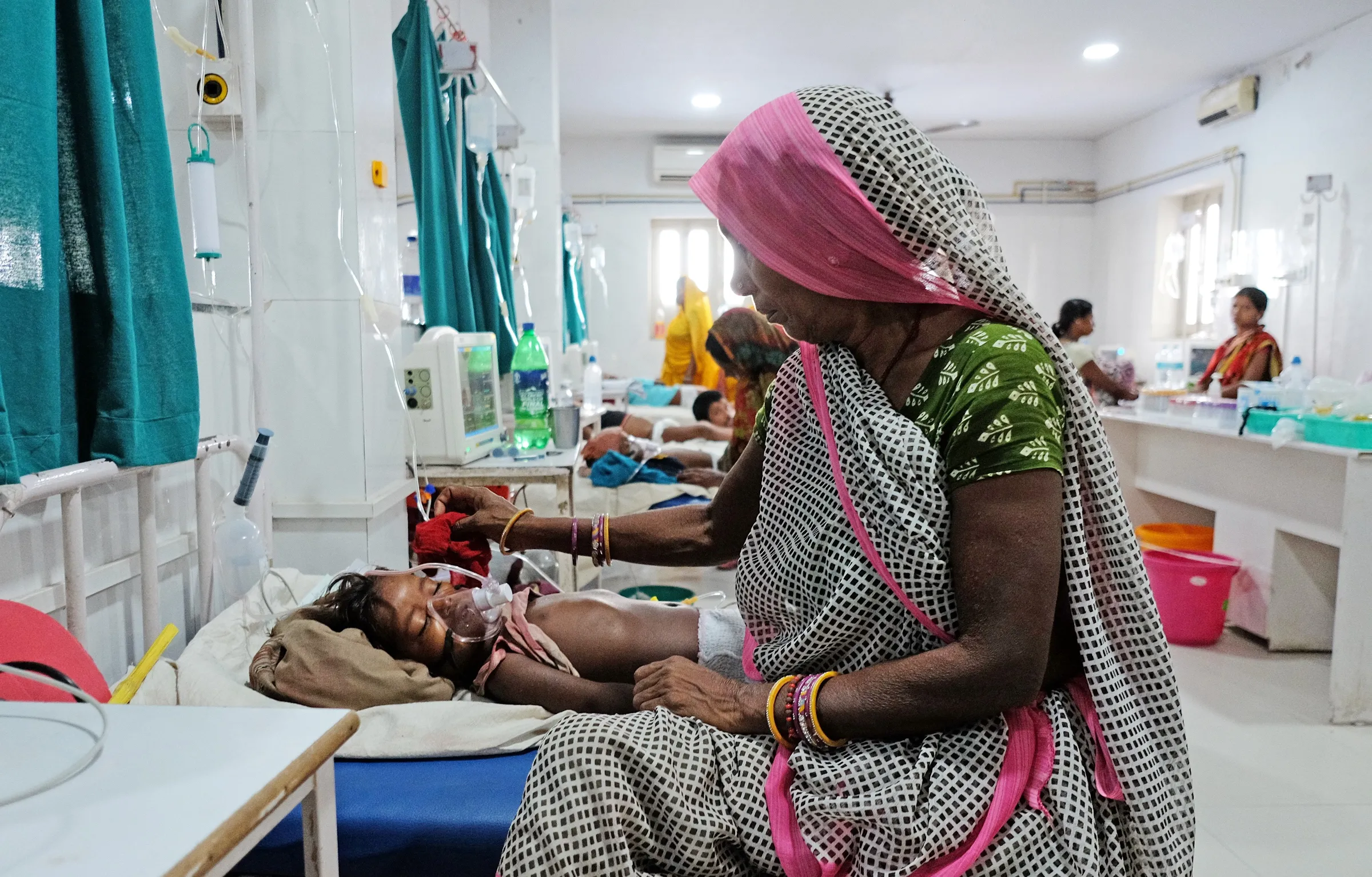 A relative sits next to a child patient who is suffering from acute encephalitis syndrome at a hospital in Bihar, India, June 20, 2019. REUTERS/Alasdair Pal