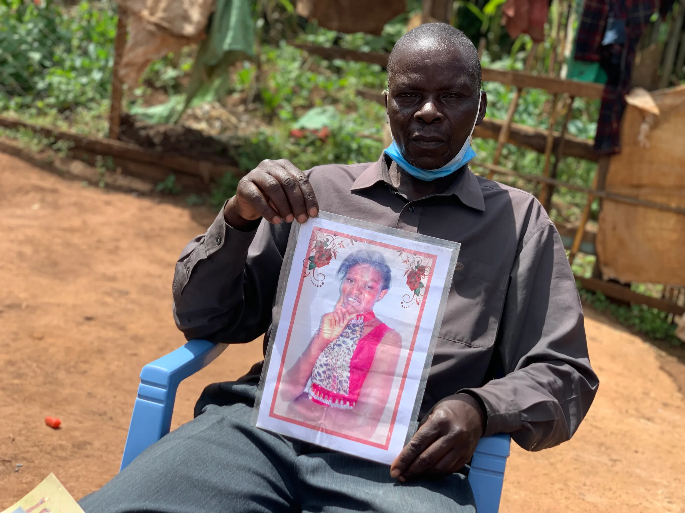 John Tindo holds a picture of his daughter Alice Awor Tindo who died while working in Saudi Arabia in Elburgon, Kenya