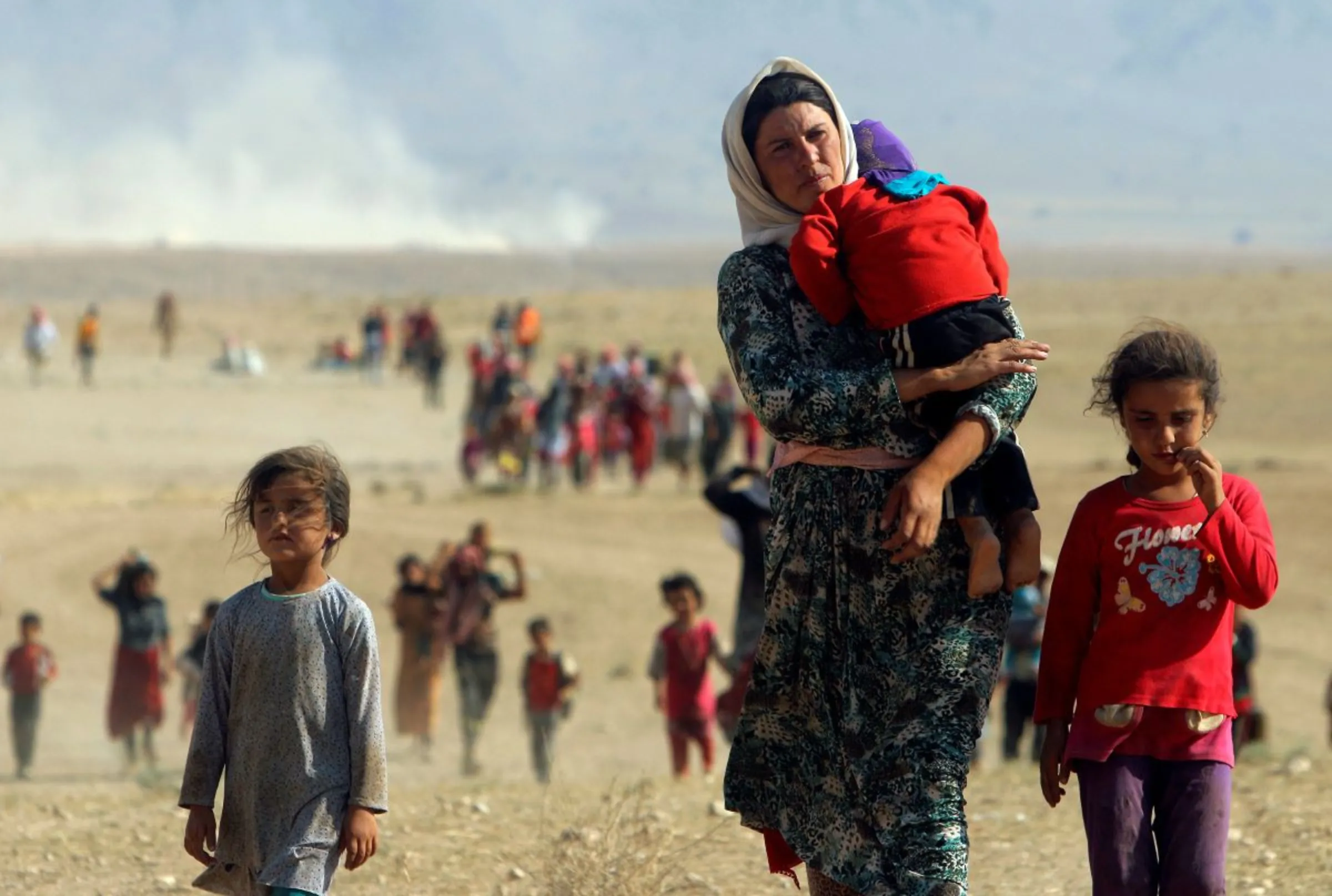 Displaced people walk towards the Syrian border near the town of Elierbeh of Al-Hasakah Governorate, Iraq, August 11, 2014. REUTERS/Rodi Said