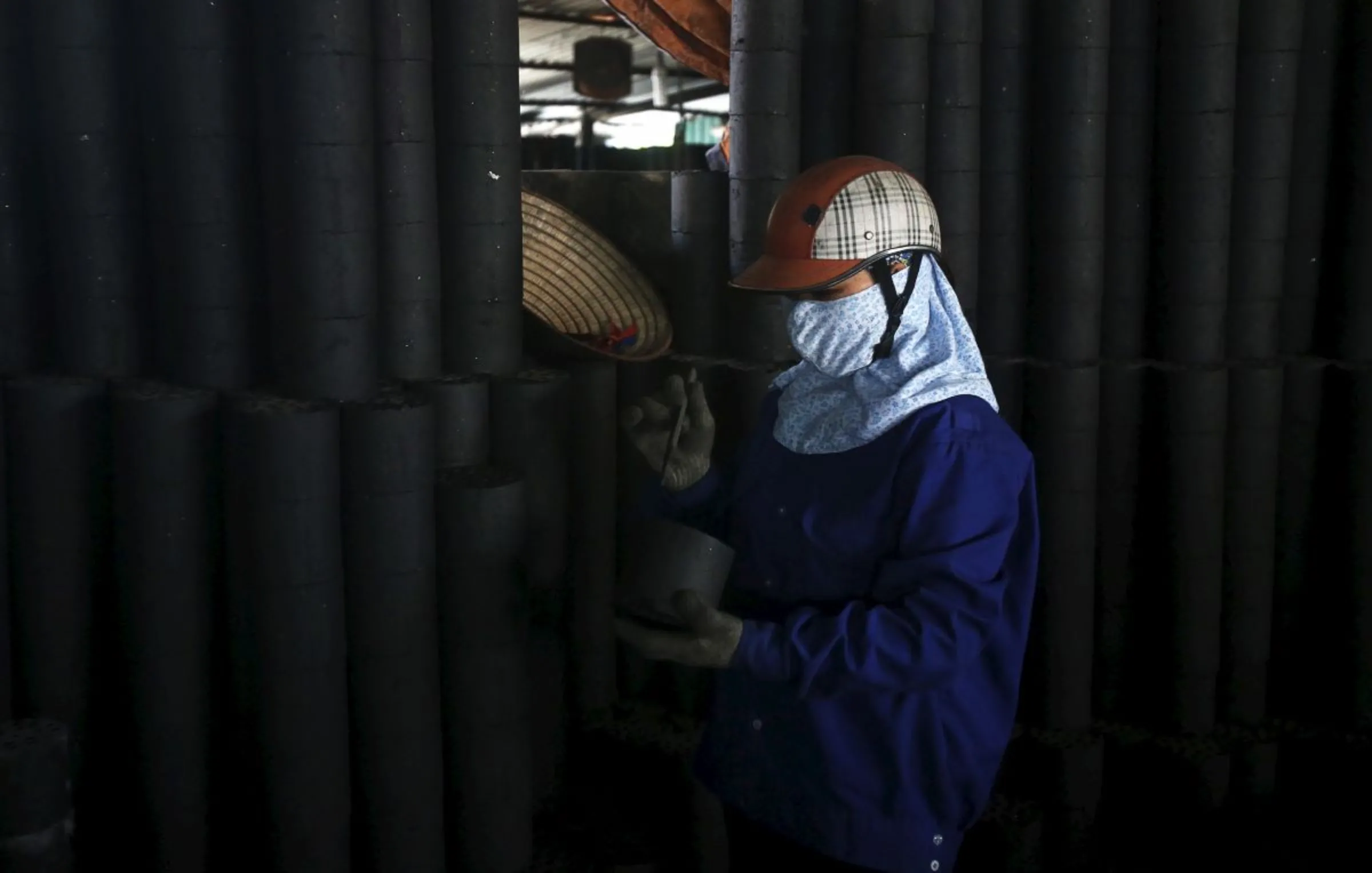 A woman works at a coal factory outside Hanoi, Vietnam June 16, 2015. REUTERS/Kham