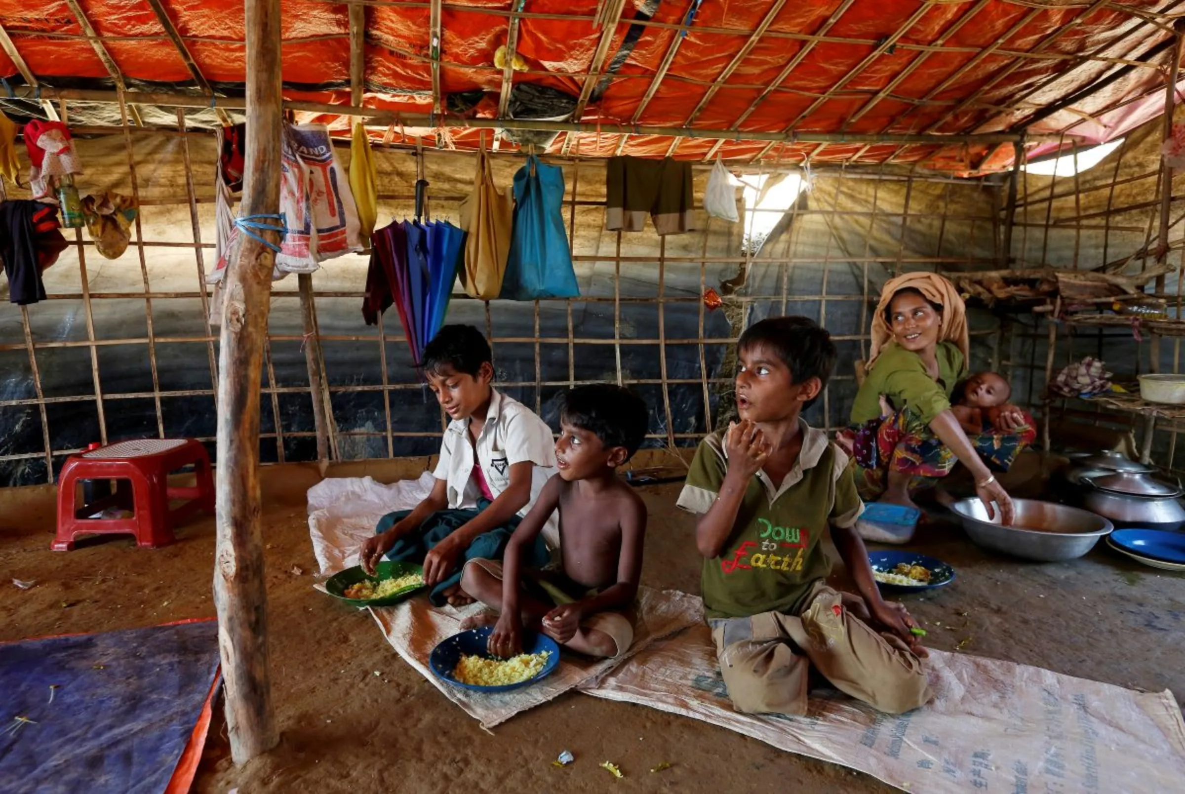 A mother and her children eat lunch together in their shelter at Palong Khali refugee camp, near Cox's Bazar, Bangladesh, November 3, 2017
