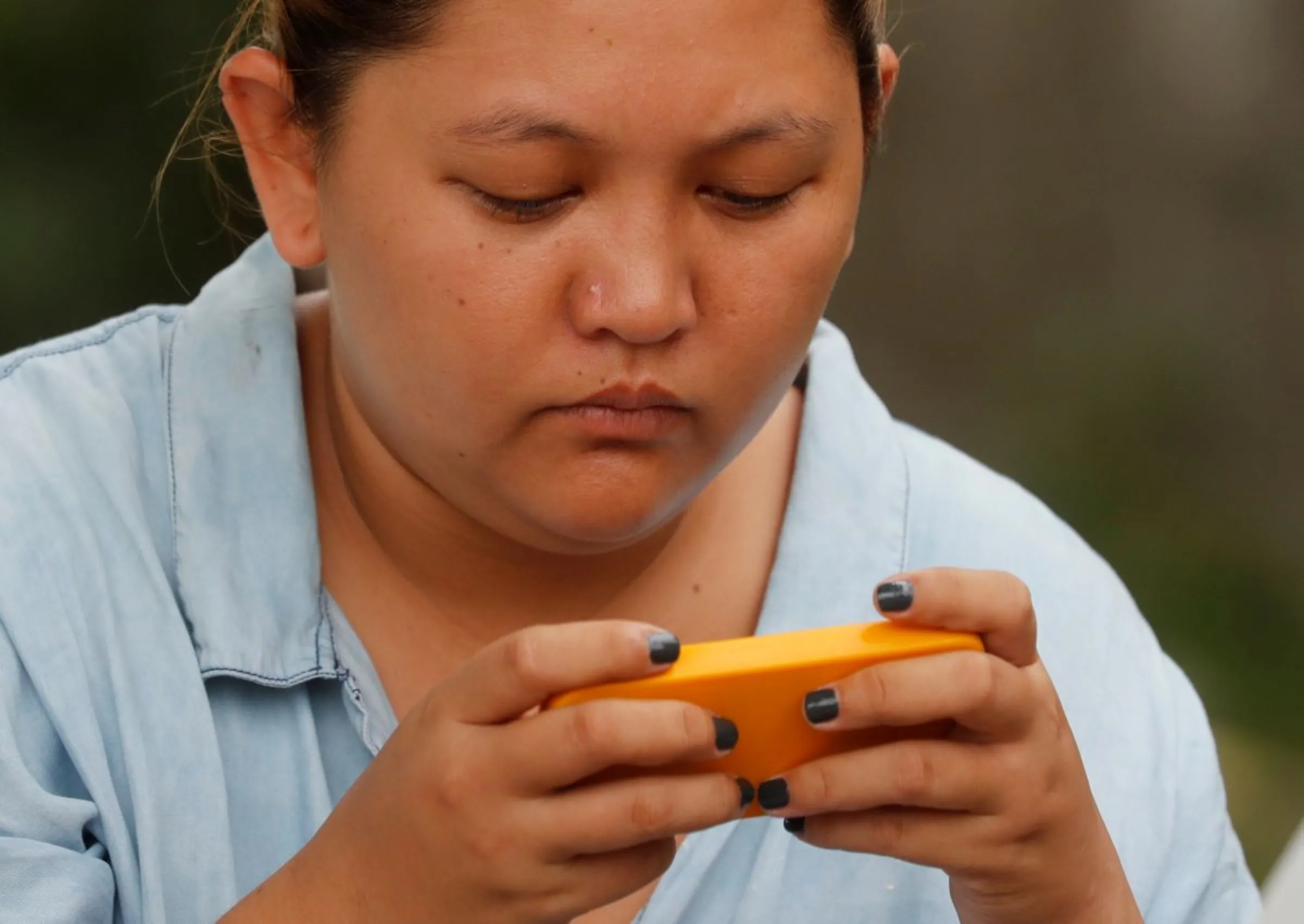 A woman uses her mobile phone to play online computer games in Imus, Cavite, in Philippines, August 8, 2018. Picture taken August 8, 2018. REUTERS/Erik De Castro