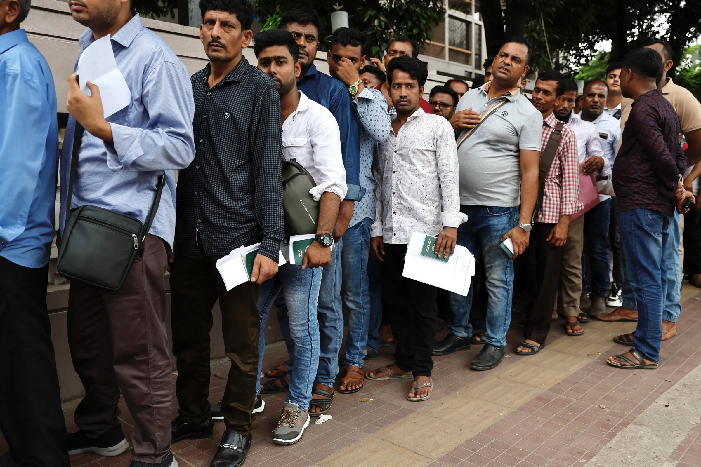 Migrant workers stand in queue to purchase air-tickets of Saudi Airlines after protests by students against government job quotas, in Dhaka, Bangladesh, July 21, 2024. REUTERS/Mohammad Ponir Hossain