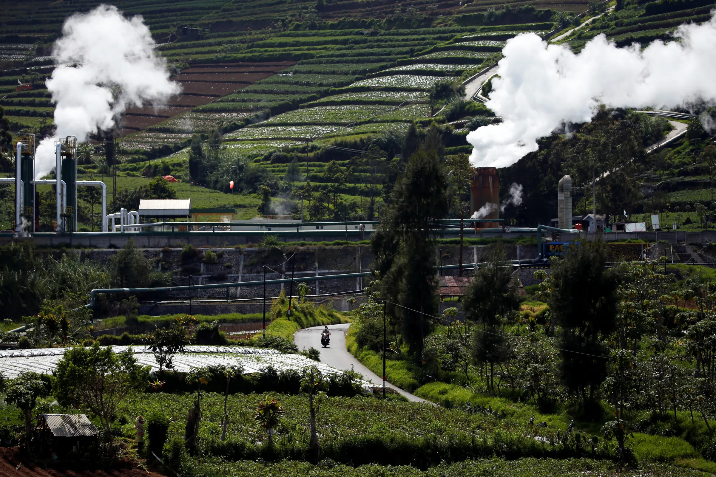 A local rides a motorbike on a road near geothermal power station unit (PLTP) owned by PT. Geo Dipa Energi (Persero) at Dieng mountain area in Banjarnegara, Central Java, Indonesia, November 15, 2020