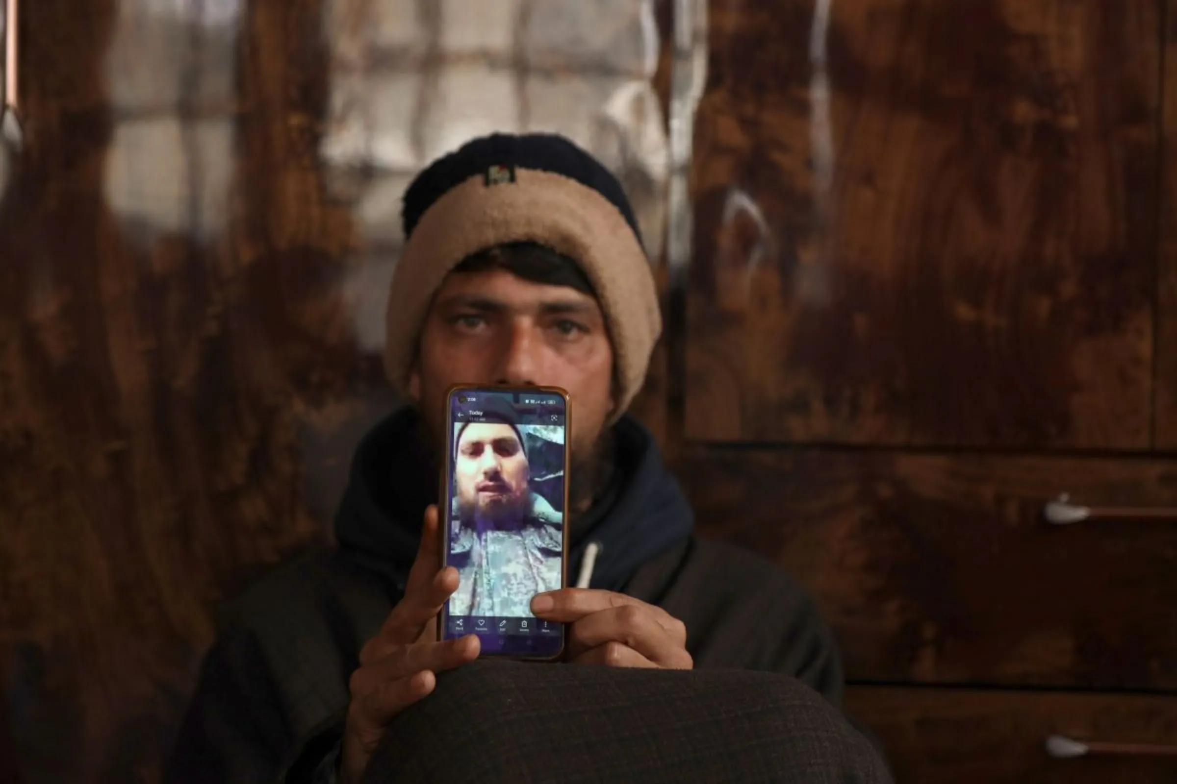 Sajad Kumar, brother of Azad Yousuf Kumar, who got duped into fighting in the Russia-Ukraine war, shows a photo of his brother on his mobile phone at their home in Poshwan, Kashmir, Febraury 28, 2024. Thomson Reuters Foundation/Kamran Yousuf