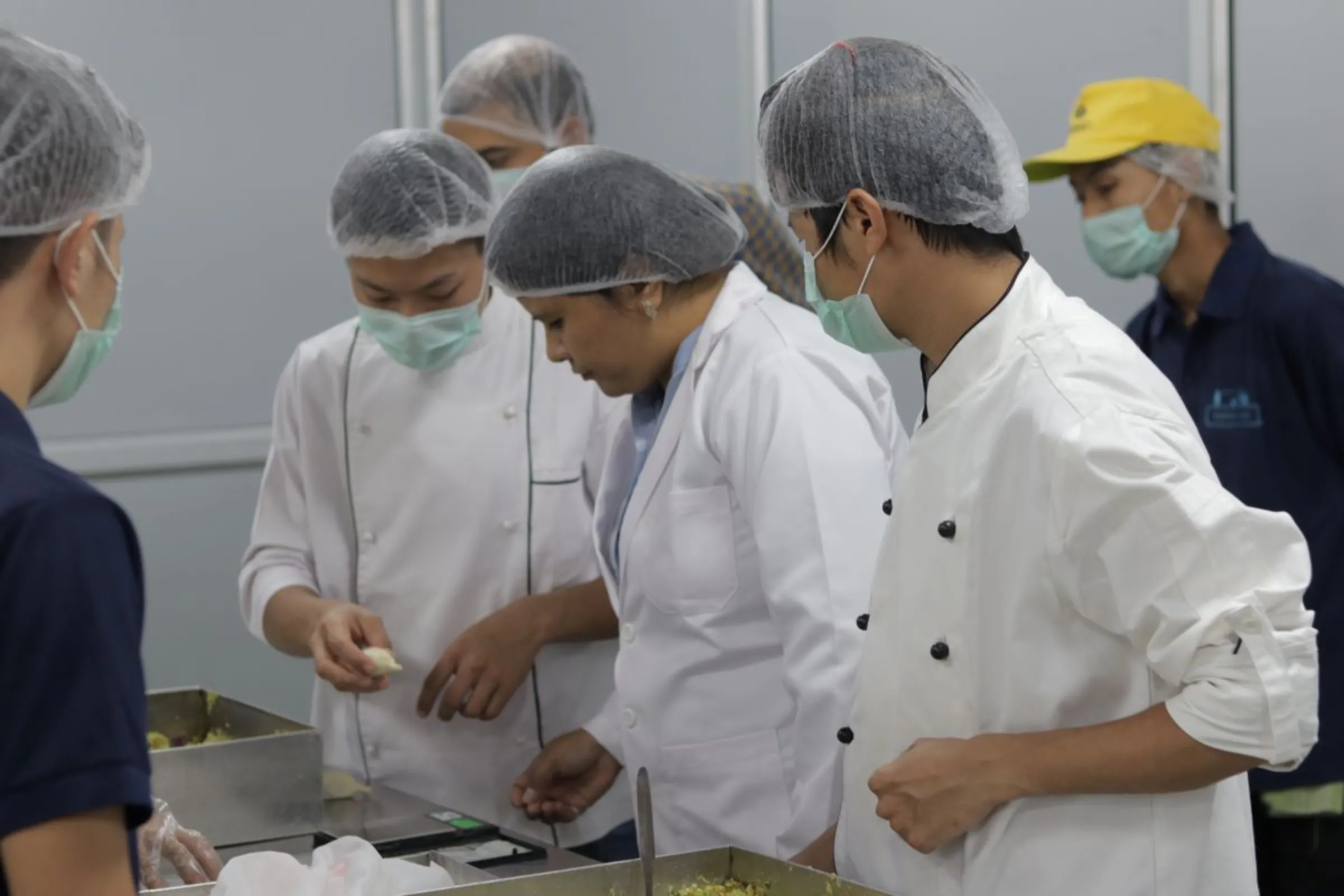 Aditi Madan (centre), co-founder of BluePine Foods, at a production unit with her staff and craftsmen discussing weightage of their products, momos. Aditi Madan/Handout via Thomson Reuters Foundation