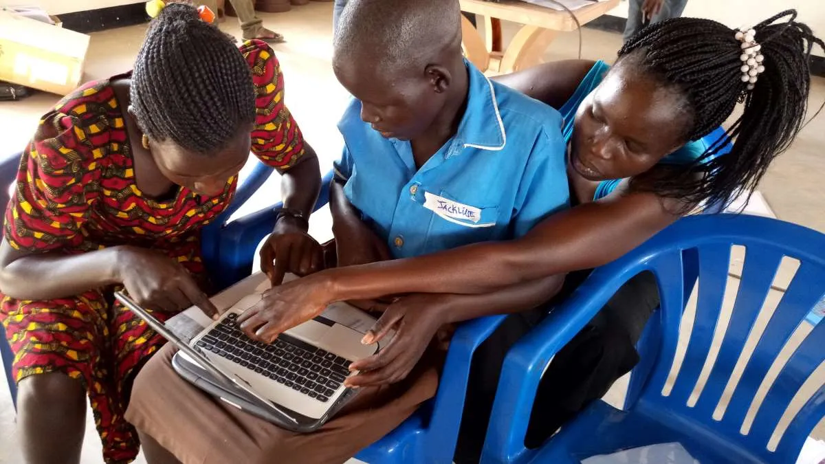 Students gather around a computer during ICT training for South Sudanese refugees in the West Nile region in Northern Uganda. Thomson Reuters Foundation/Handout courtesy of BOSCO