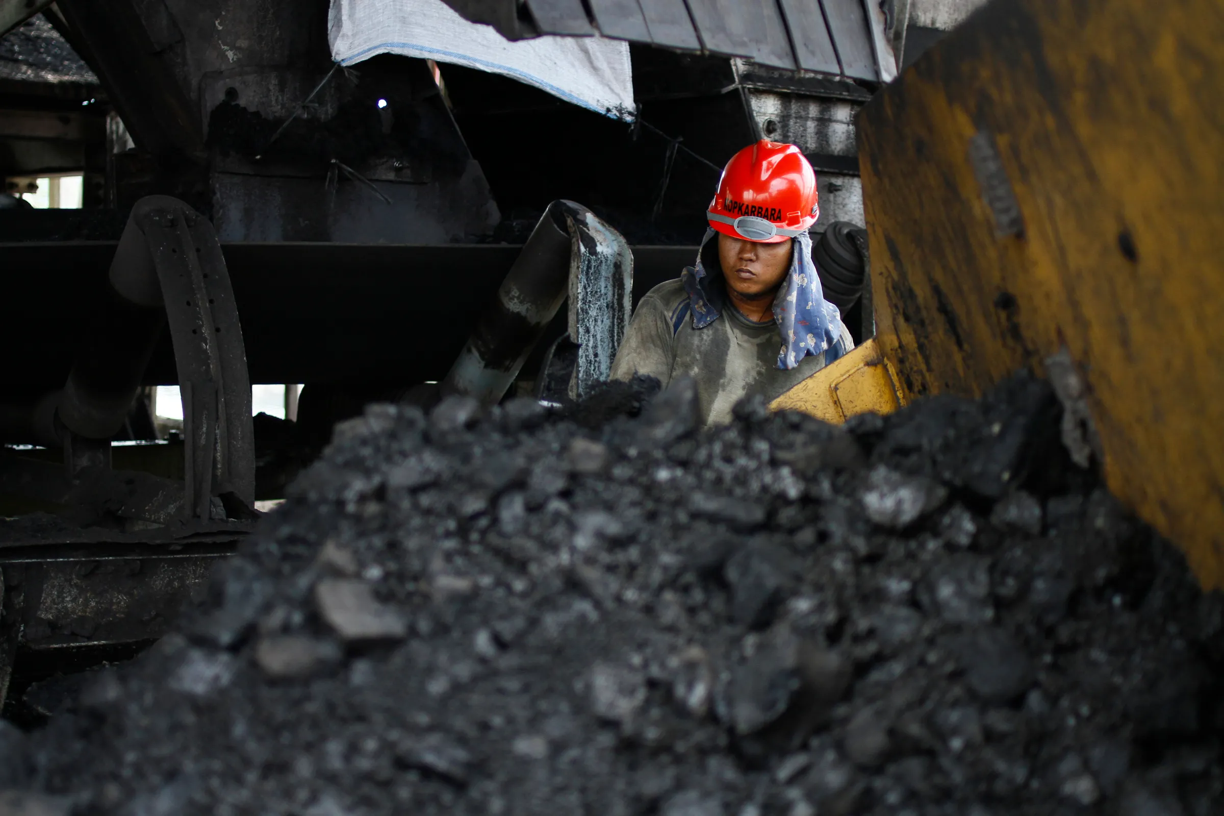 A coal worker cleans a conveyor belt at the Tarahan coal port in Lampung province, Indonesia, August 20, 2011.  REUTERS/Dwi Oblo