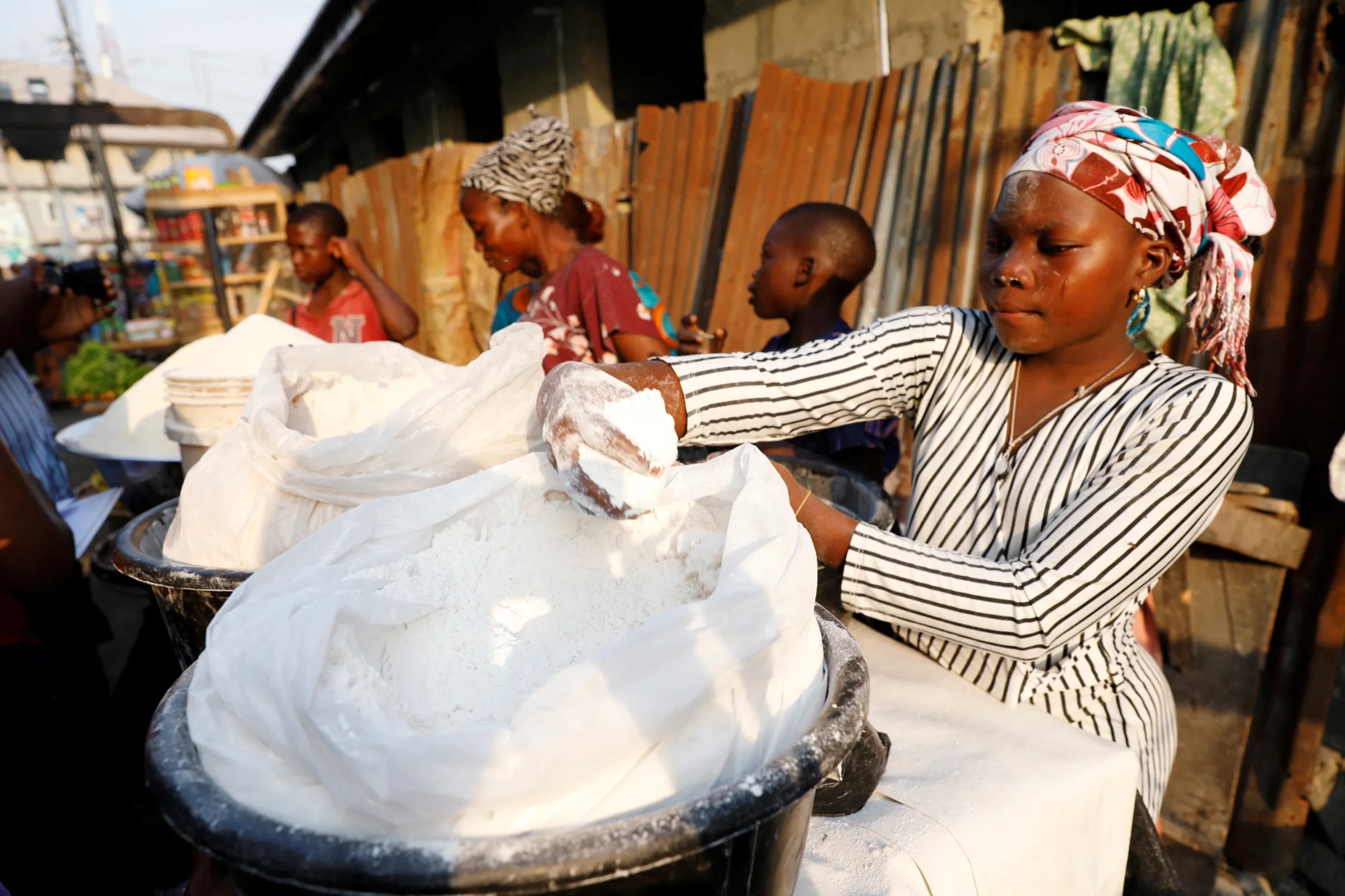 A vendor sells cassava flour at a traditional market in Bariga district, in Lagos, Nigeria