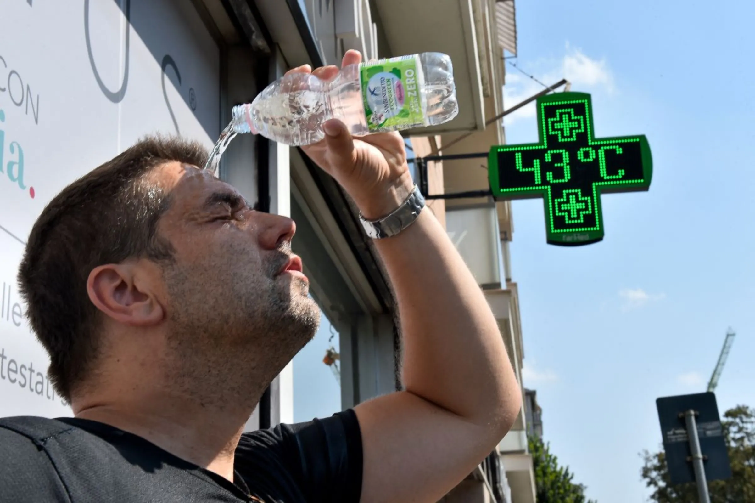 A man pours water on himself during a heatwave in Turin, Italy, August 25, 2023. REUTERS/Massimo Pinca