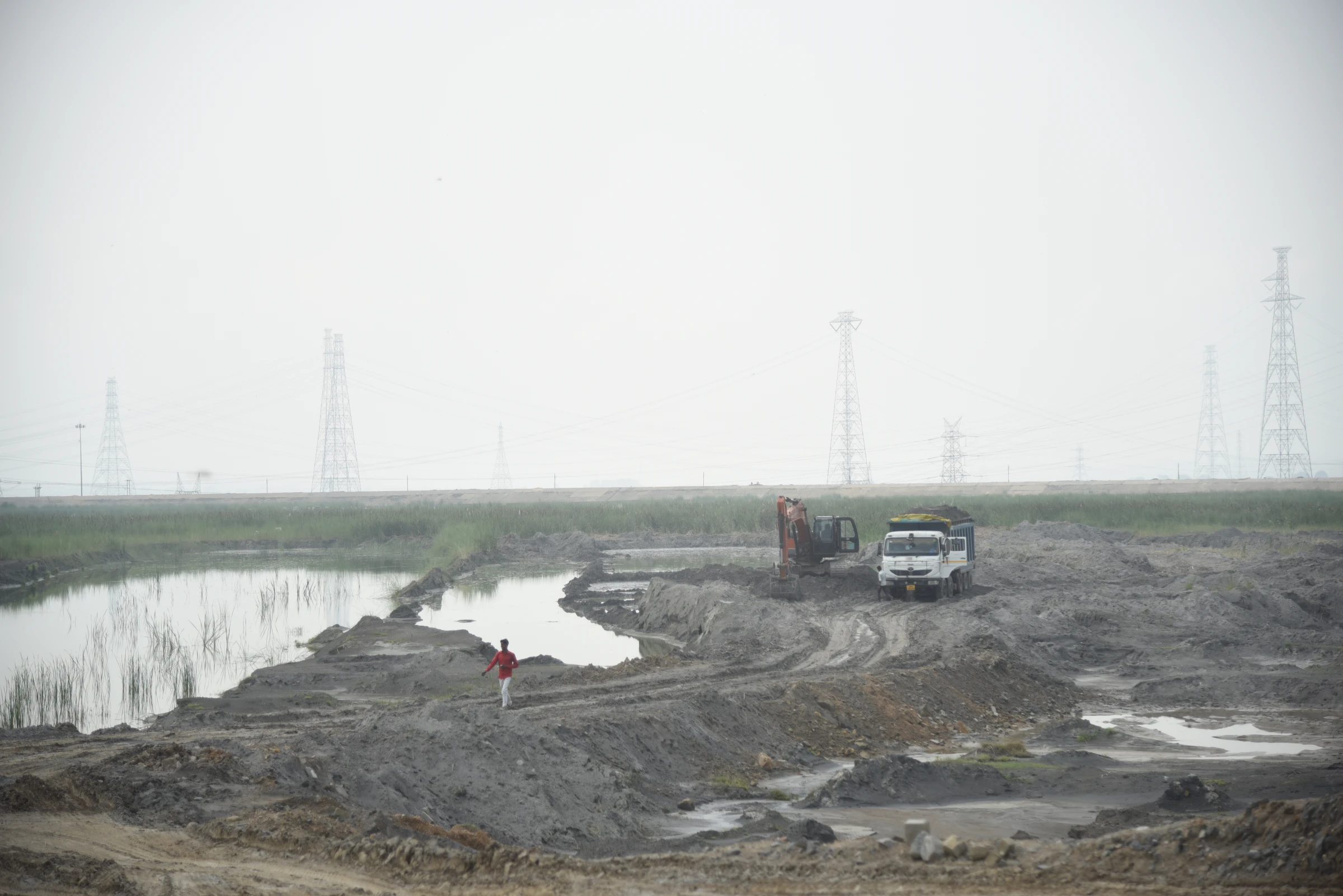 A truck is being loaded with coal fly ash stored wet in an ash dump in Singrauli, India, on August 28, 2024. Thomson Reuters Foundation/Tanmoy Bhaduri