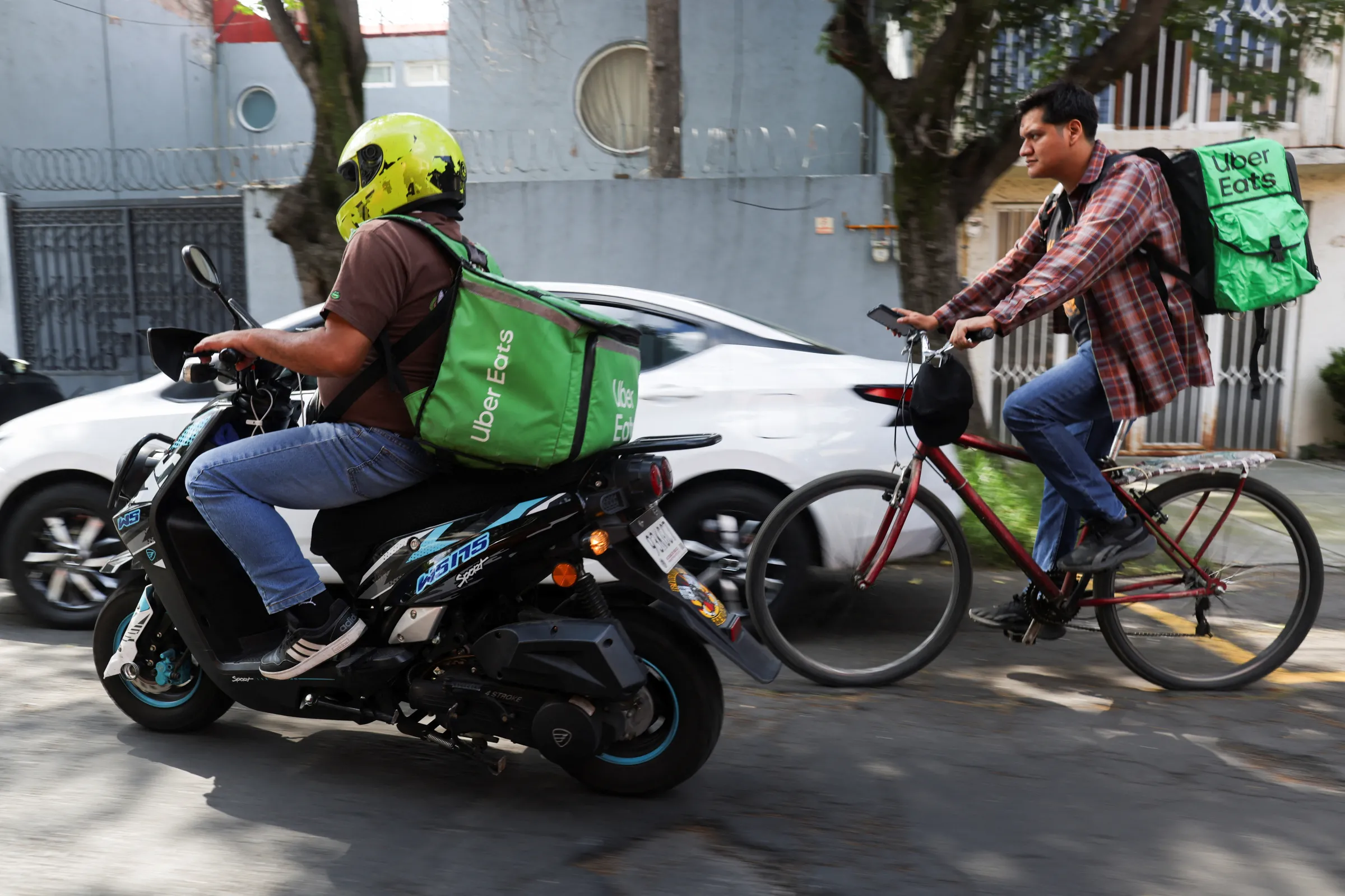 Delivery drivers for Uber Eats transport food orders as Mexico proposes a labor reform for drivers and delivery workers using applications like Uber, Didi and Rappi, officials said on Wednesday, in Mexico City, Mexico October 16, 2024. REUTERS/Gustavo Graf