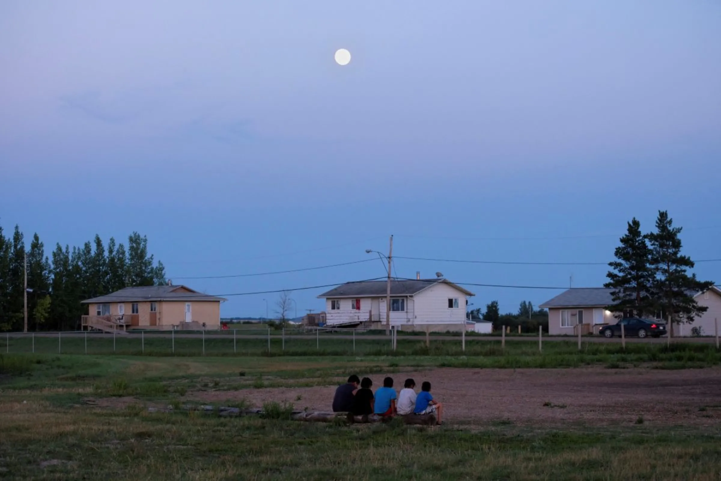 Children from the Cote First Nation sit at the campground set up by the First Nations Indigenous Warriors (FNIW) and the American Indian Movement (AIM) on the Cote First Nation, near the town of Kamsack, Saskatchewan, Canada, August 6, 2017. REUTERS/Zachary Prong