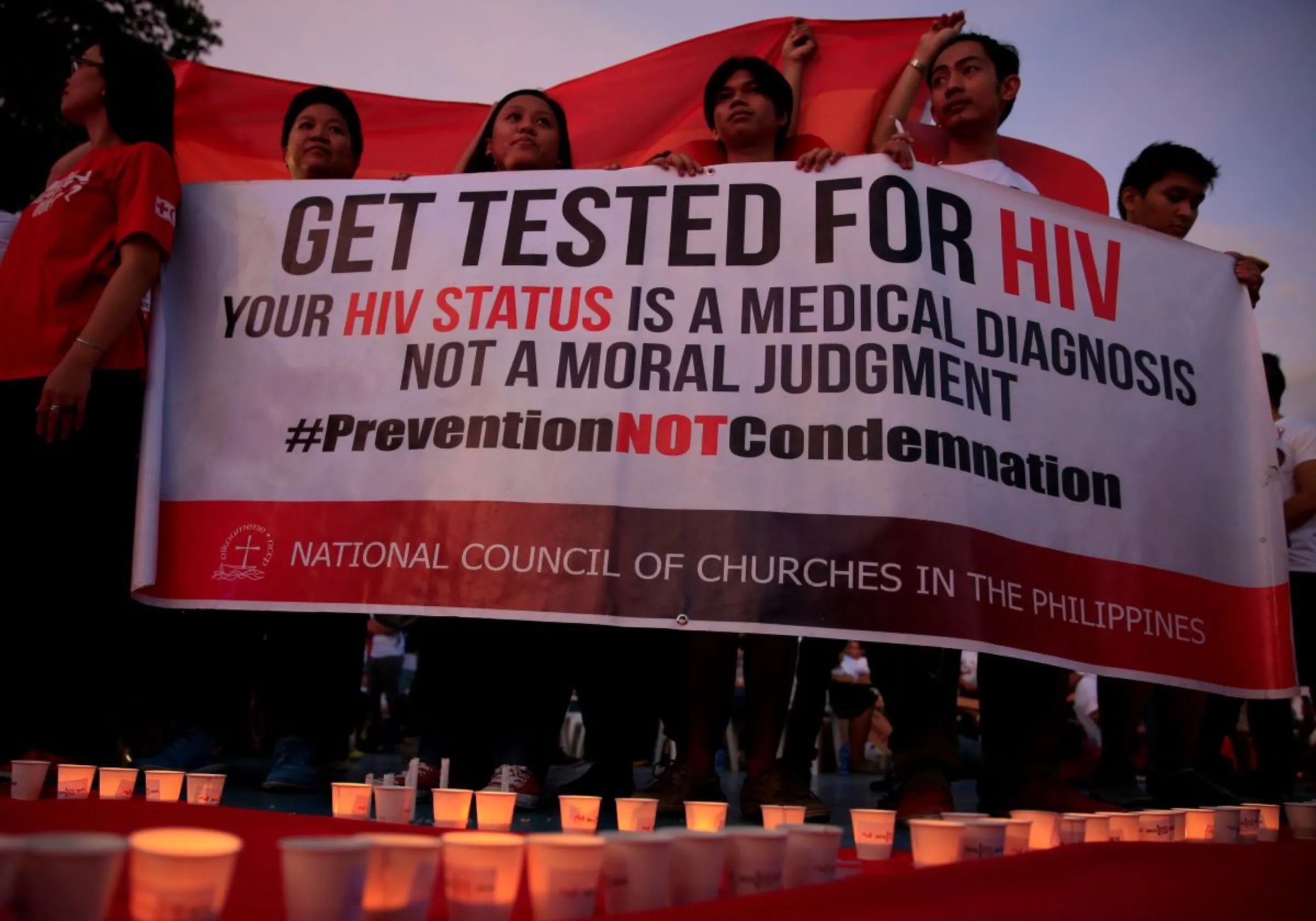 Campaign supporters display a streamer after lightning candles representing the number of dead victims claimed by HIV/AIDS in the Philippines since 1984 in Quezon city, Philippines. May 14, 2016. REUTERS/Romeo Ranoco