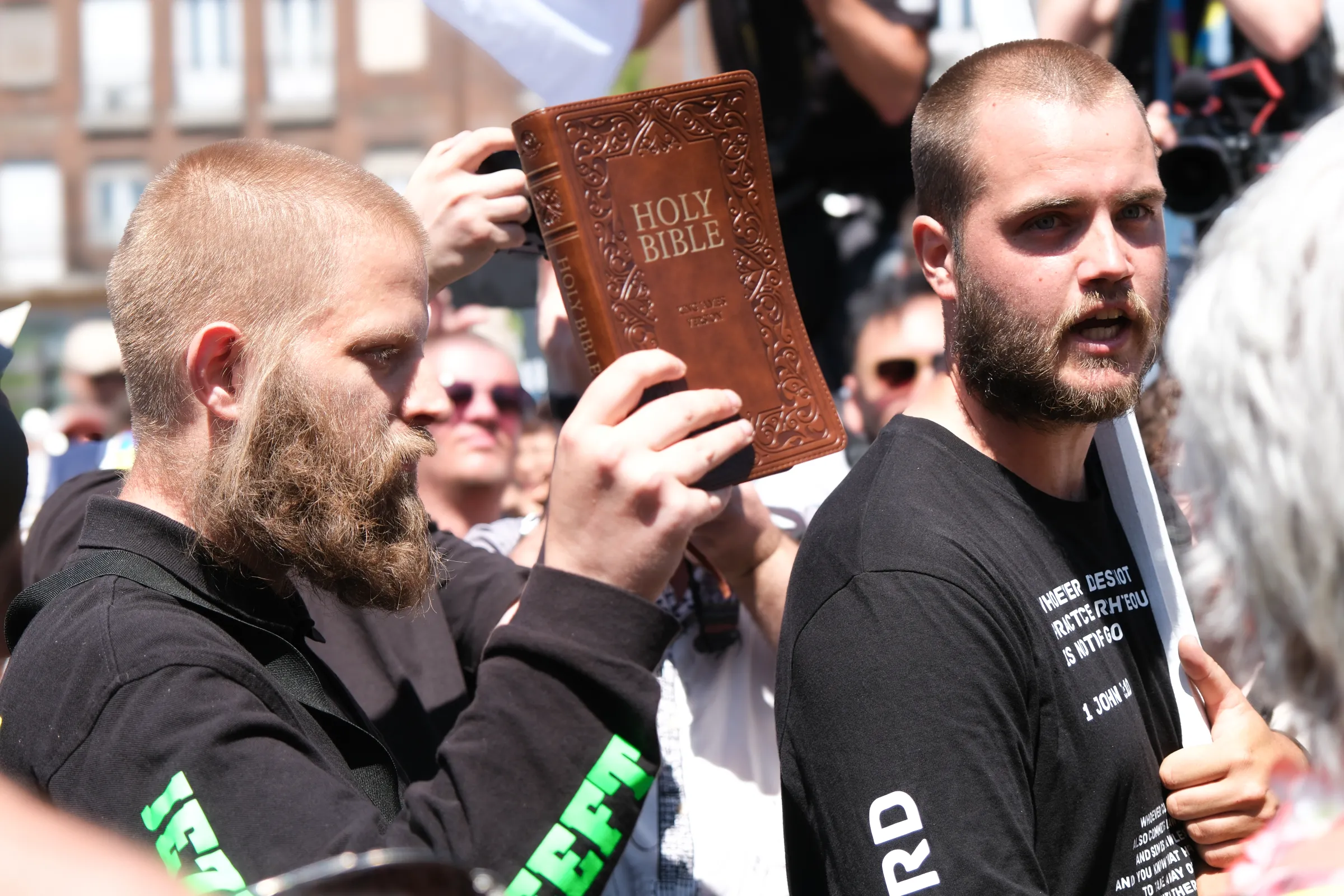 Two members of a far-right Christian nationalist group push through the crowd gathered for Budapest Pride, chanting anti LGBTQ+ slogans. Budapest, Hungary, June 28, 2025. Thomson Reuters Foundation/Mirja Vogel