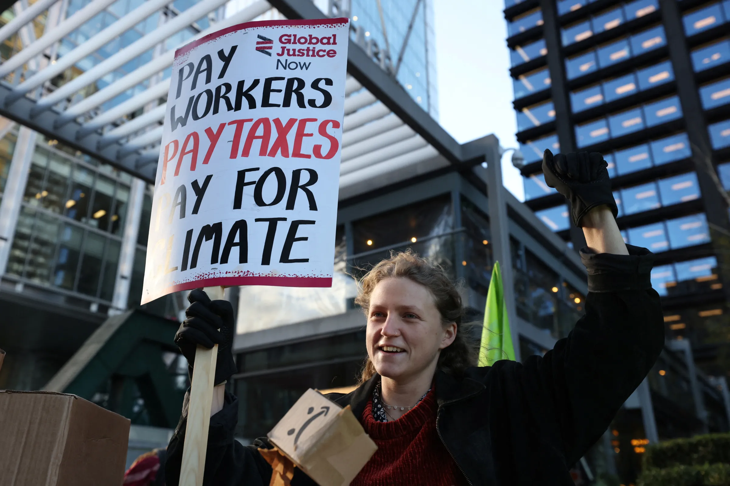 A demonstrator holds a placard during a protest outside the Amazon headquarters during Black Friday in London, Britain, November 24, 2023. REUTERS/Hollie Adams