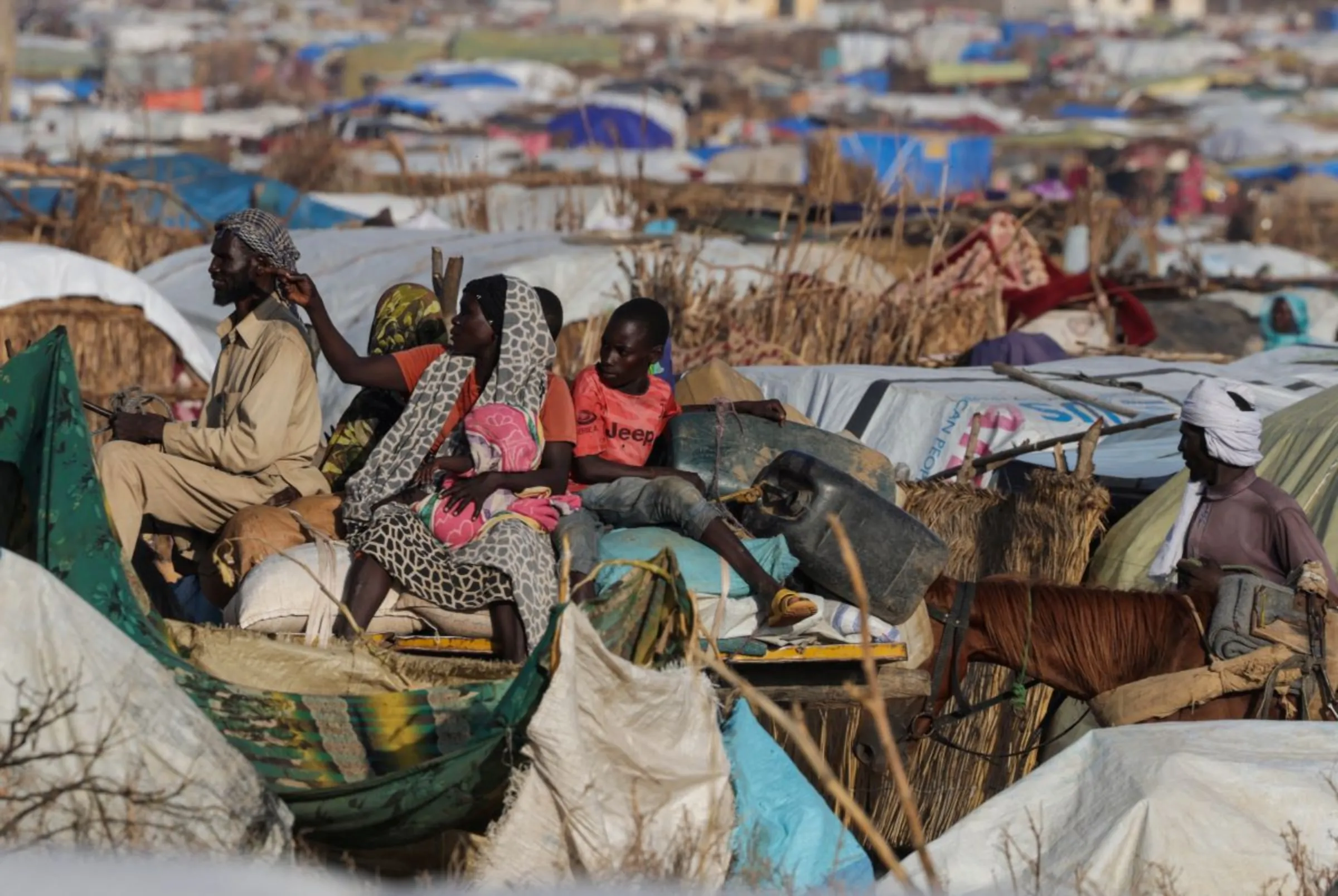 A Sudanese woman, who fled the conflict in Geneina in Sudan's Darfur region, reacts as she rides a cart alongside makeshift shelters in Adre, Chad August 5, 2023. REUTERS/Zohra Bensemra