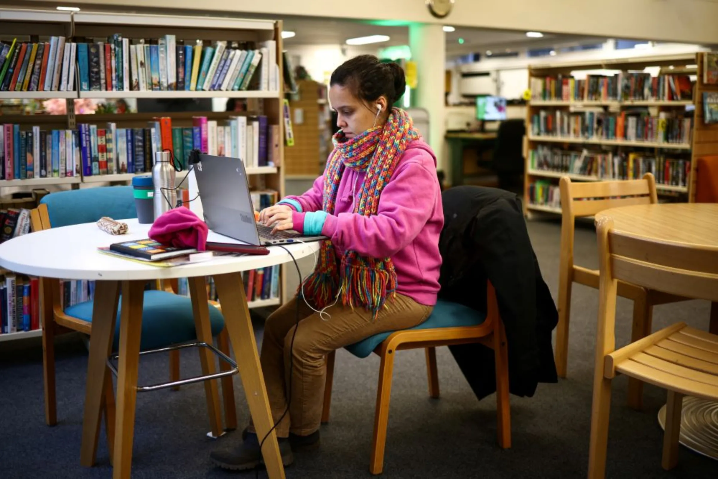 A local resident uses a laptop inside the Roehampton Library, that is being used as a 'warm bank', welcoming members of the community to spend time there in the winter months as an alternative to heating their homes amid increased energy costs, in London, Britain, December 14, 2022