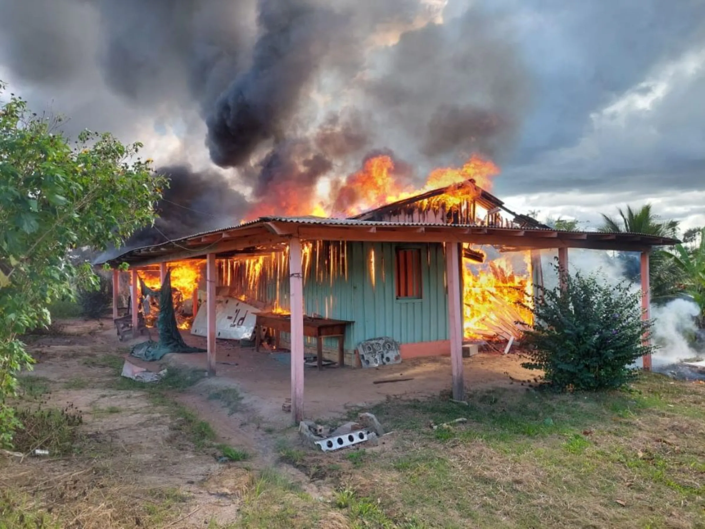 An agent of the Brazilian Institute for the Environment and Renewable Natural Resources (IBAMA), looks on as a plane and a house belonging to miners are destroyed during an operation conducted jointly within Brazil's National Indian Foundation (FUNAI) and Brazilian National Public Security Force against illegal mining in Yanomami indigenous land in Roraima state, Brazil February 6, 2023