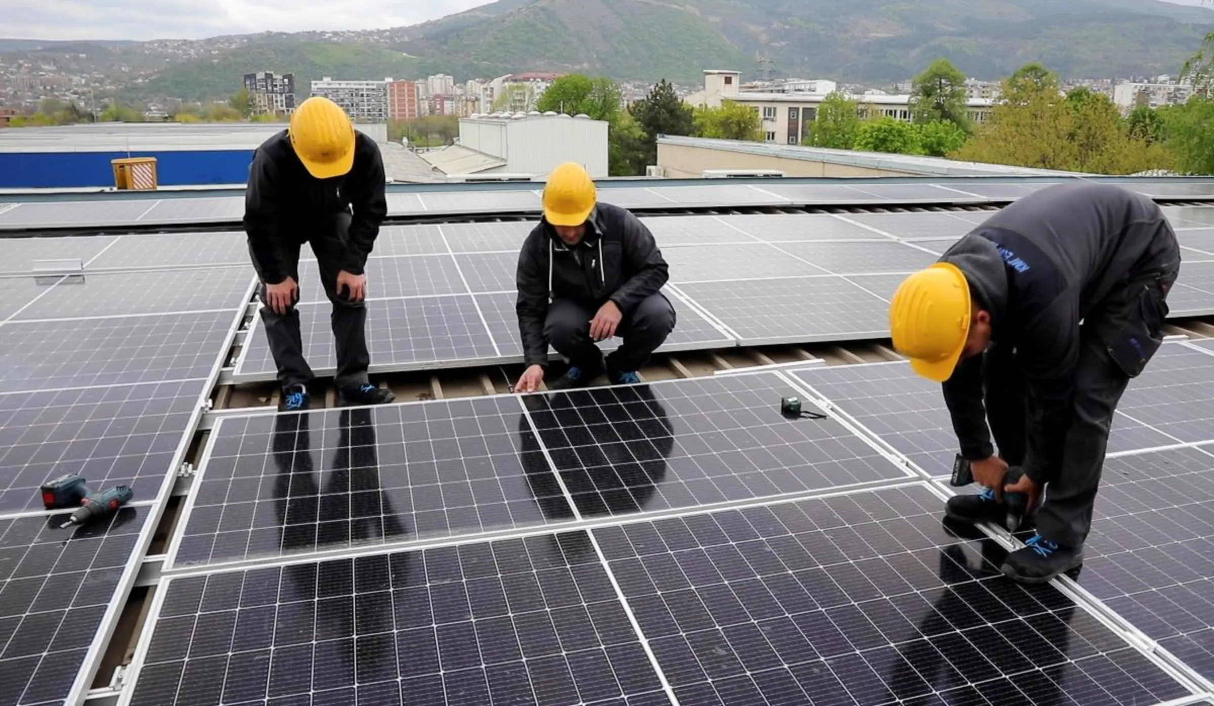 Workers install solar panels on an office building in Skopje, North Macedonia April 19,2023. REUTERS/Ognen Teofilovski