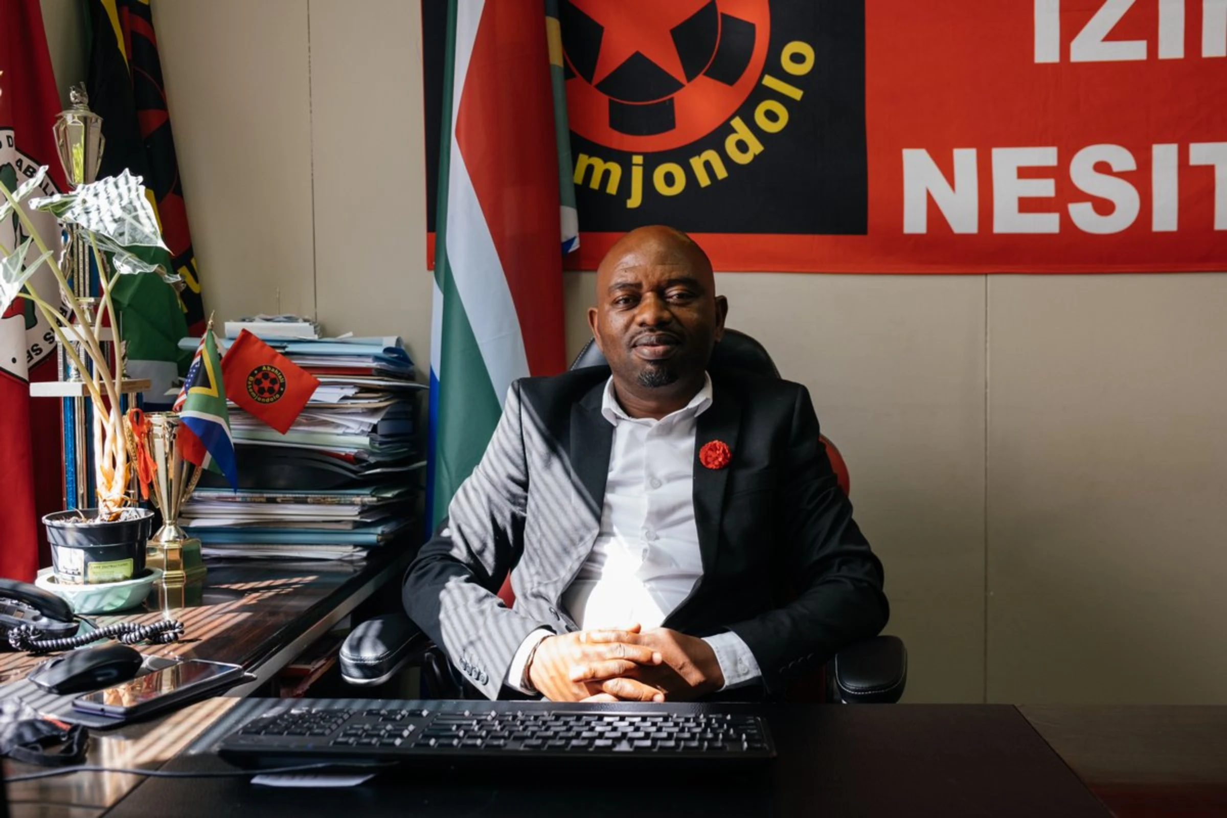 Sibusiso Zikode, a founding member of the South African shack dwellers movement Abahlali baseMjondolo sits at a desk at the organisation's headquarters in Durban, March 30, 2021. He has been recognised for his work promoting human rights and democracy, in particular for vulnerable communities living in informal settlements in Durban and the rest of South Africa