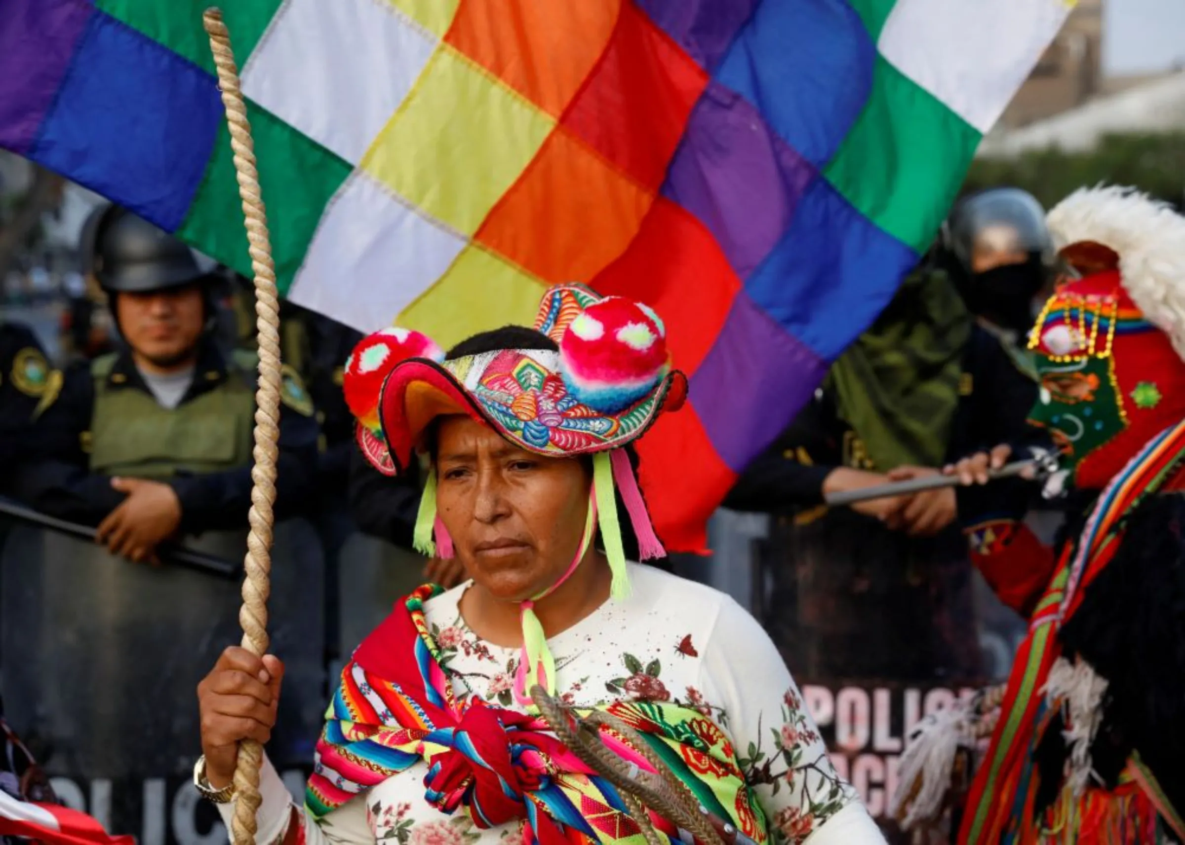 A demonstrator stands in front of riot police officers standing guard during a protest to demand Peru's President Dina Boluarte to step down, in Lima, Peru, January 31, 2023