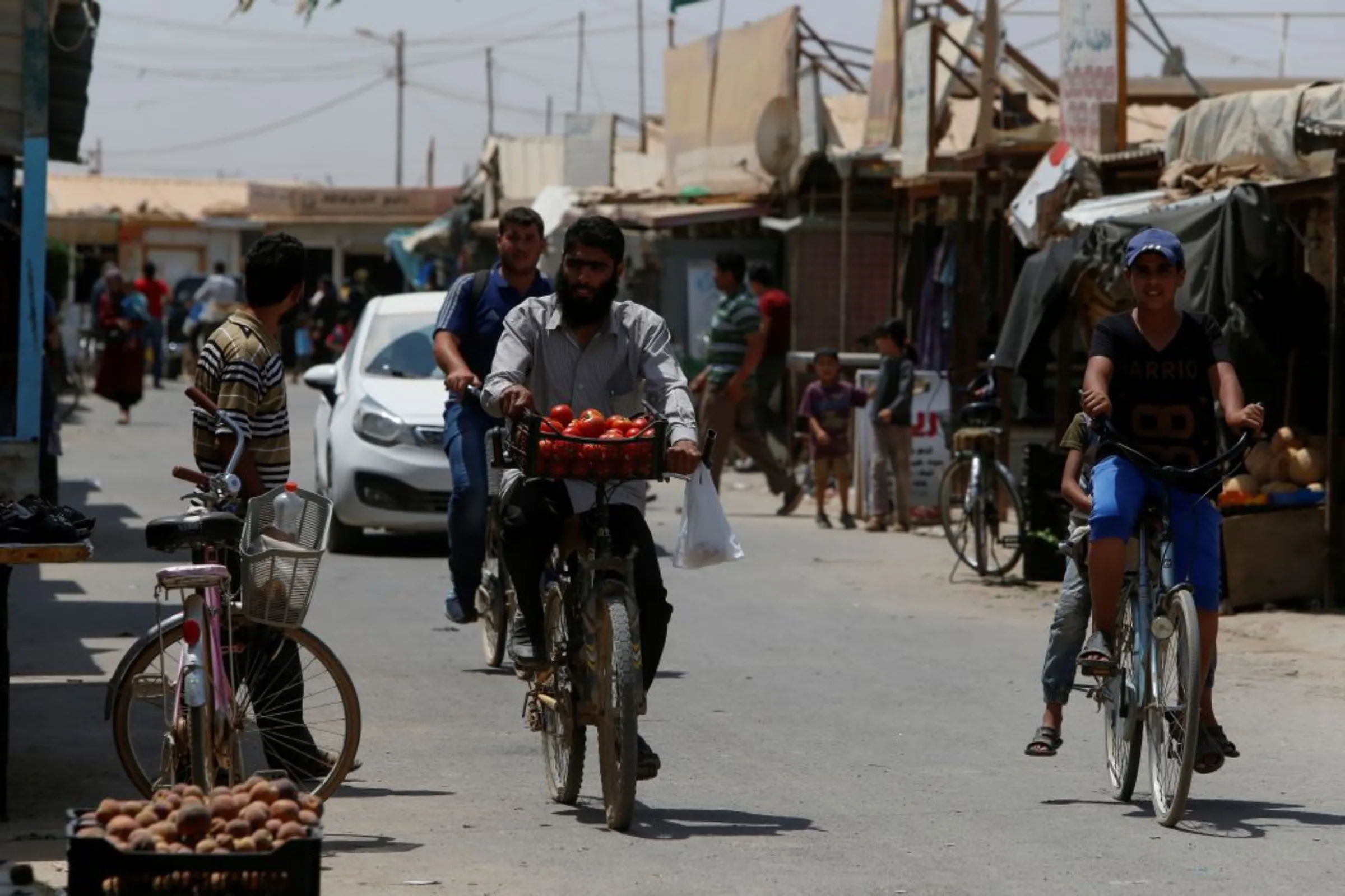 Syrian refugees ride their bicycles at the main market in Al Zaatari refugee camp outside the city of Mafraq in Jordan, near the border with Syria, July 17, 2017