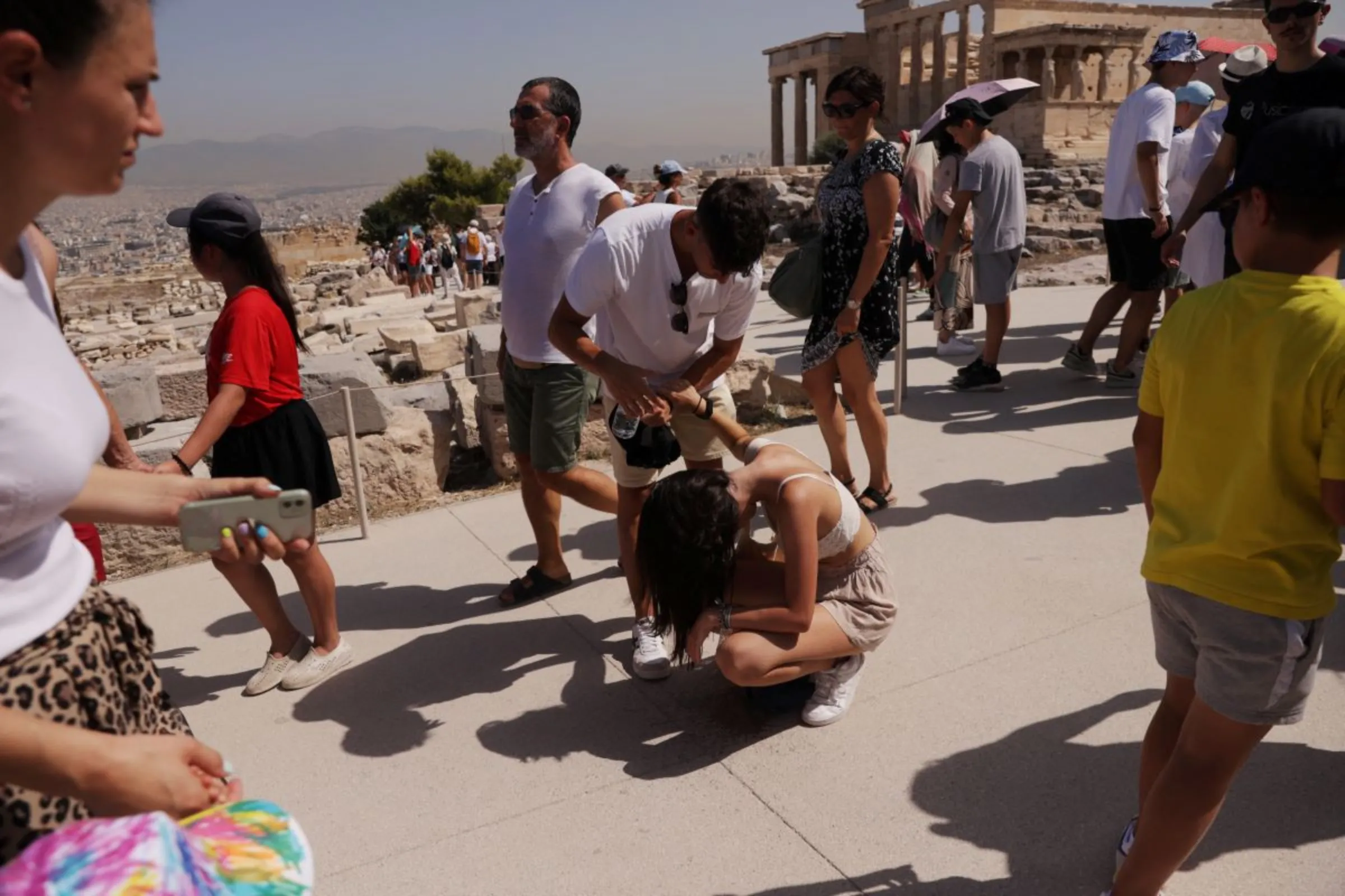 A visitor is affected by the heat atop the Acropolis hill, during a heatwave in Athens, Greece, July 14, 2023. REUTERS/Louiza Vradi