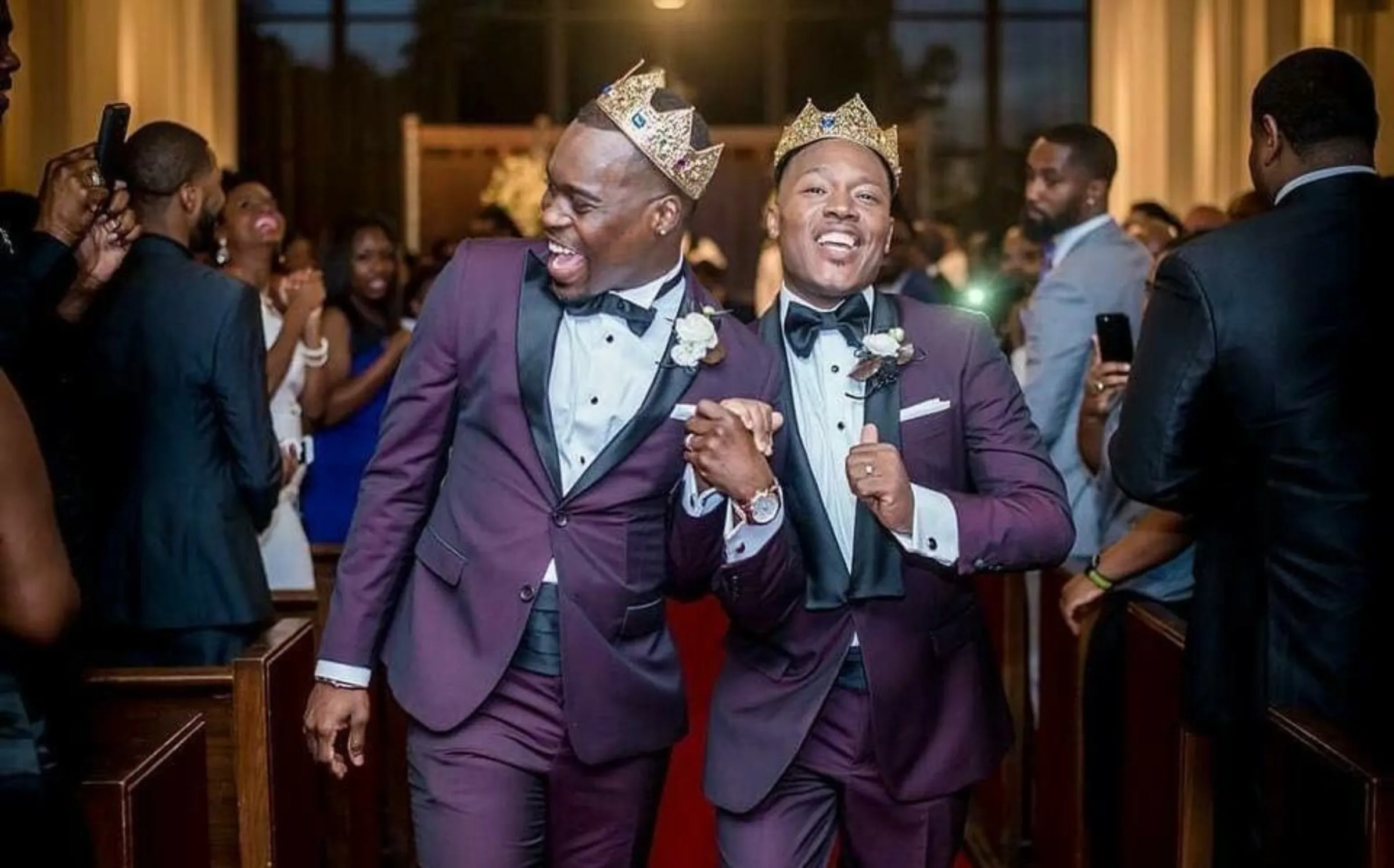 Adrian Homer (left) and his husband Harrison Guy (right) walk down the aisle together wearing crowns at the University of Houston's A.D. Bruce Religion Center on April 15, 2017. Harrison Guy/Handout via Thomson Reuters Foundation.
