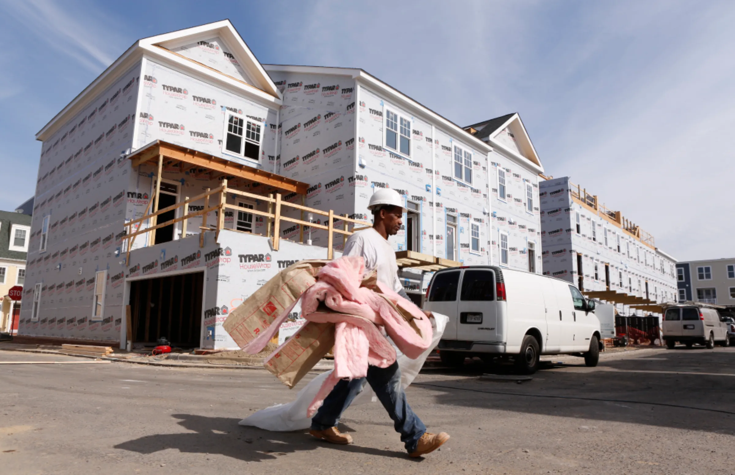 A worker carries insulation at a new housing construction site in Alexandria, Virginia October 17, 2012