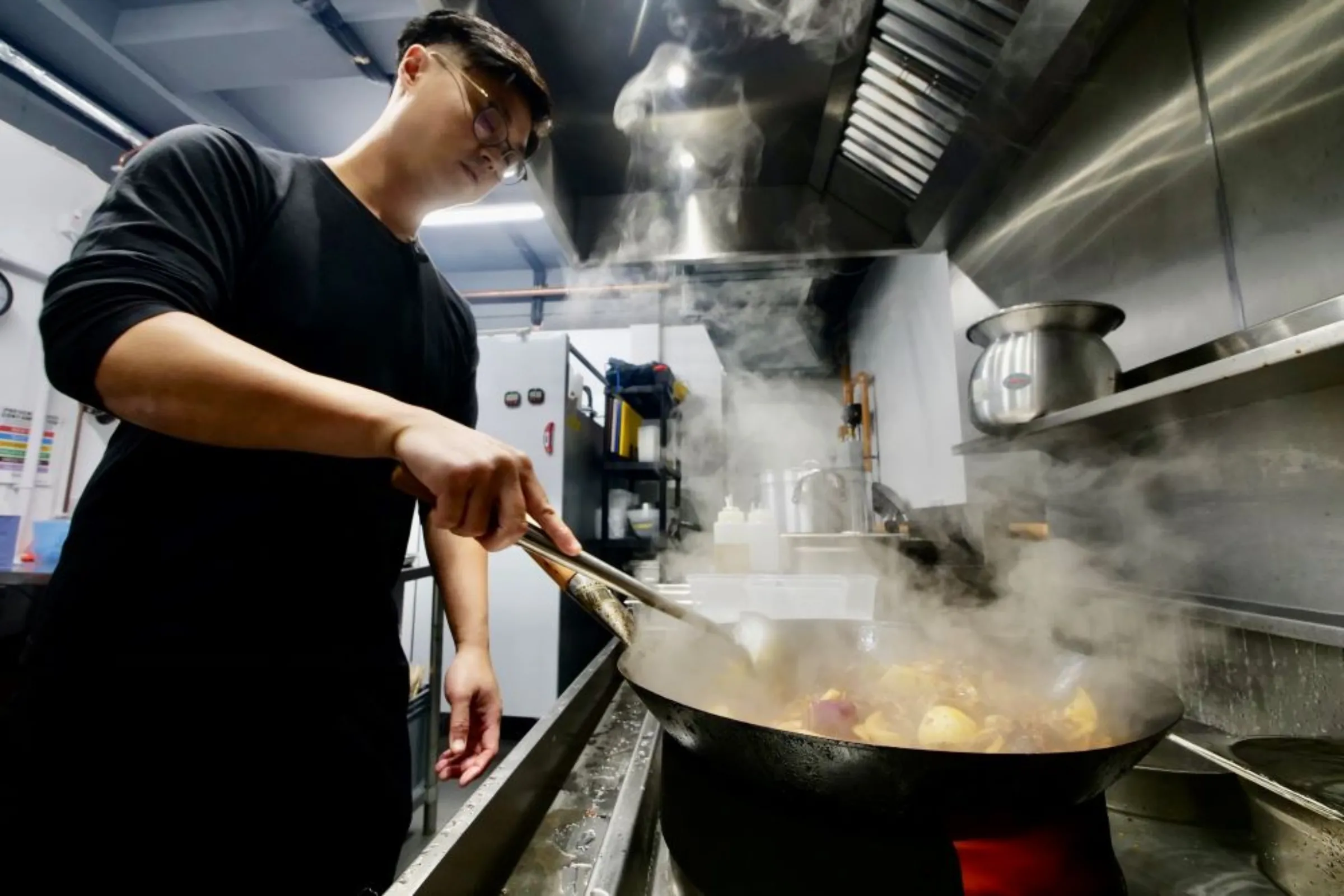 Sam Wong works in his kitchen in Croydon, south London, in September 2022. Chiu Kwan Yi/Green Bean Media/Handout via Thomson Reuters Foundation