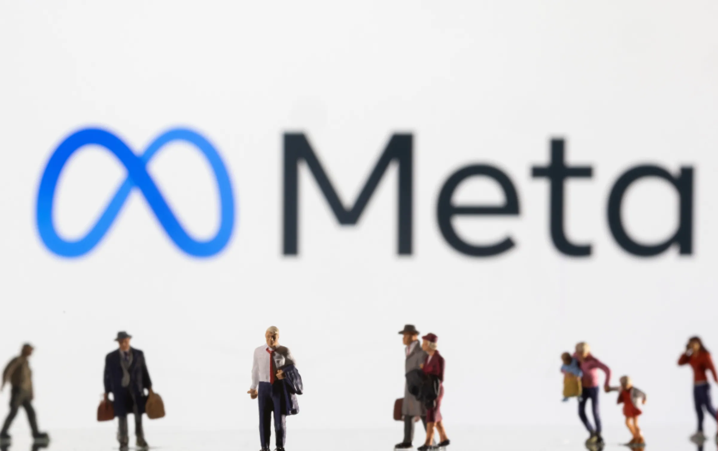 Small figurines are seen in front of displayed Meta logo in this illustration taken February 11, 2022