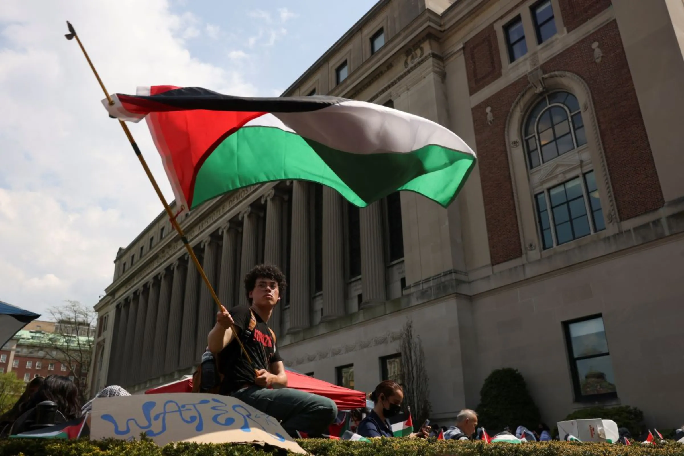 A student waves a flag during a march on Columbia University campus in support of a protest encampment supporting Palestinians, in New York City, U.S., April 29, 2024. REUTERS/Caitlin Ochs