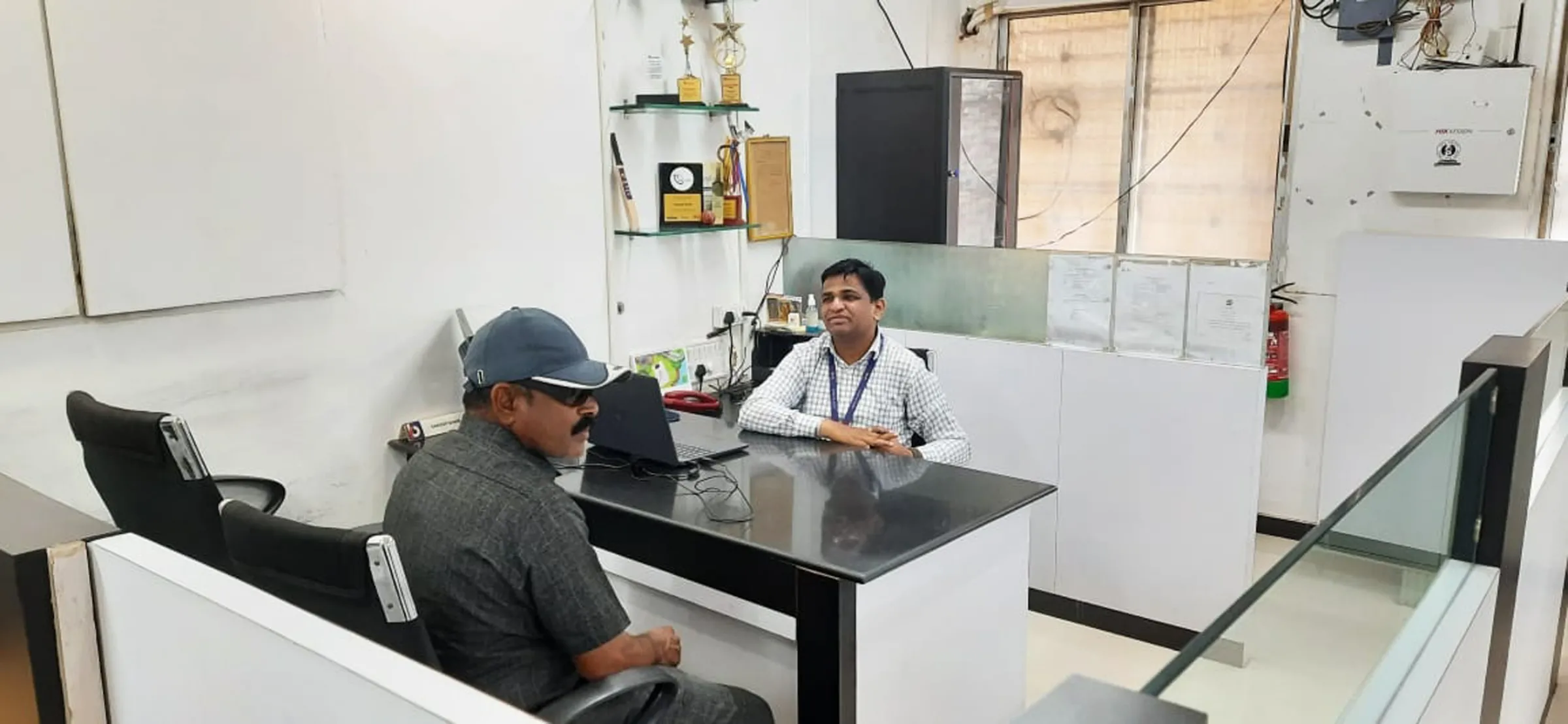 Two men sit opposite each other in an office