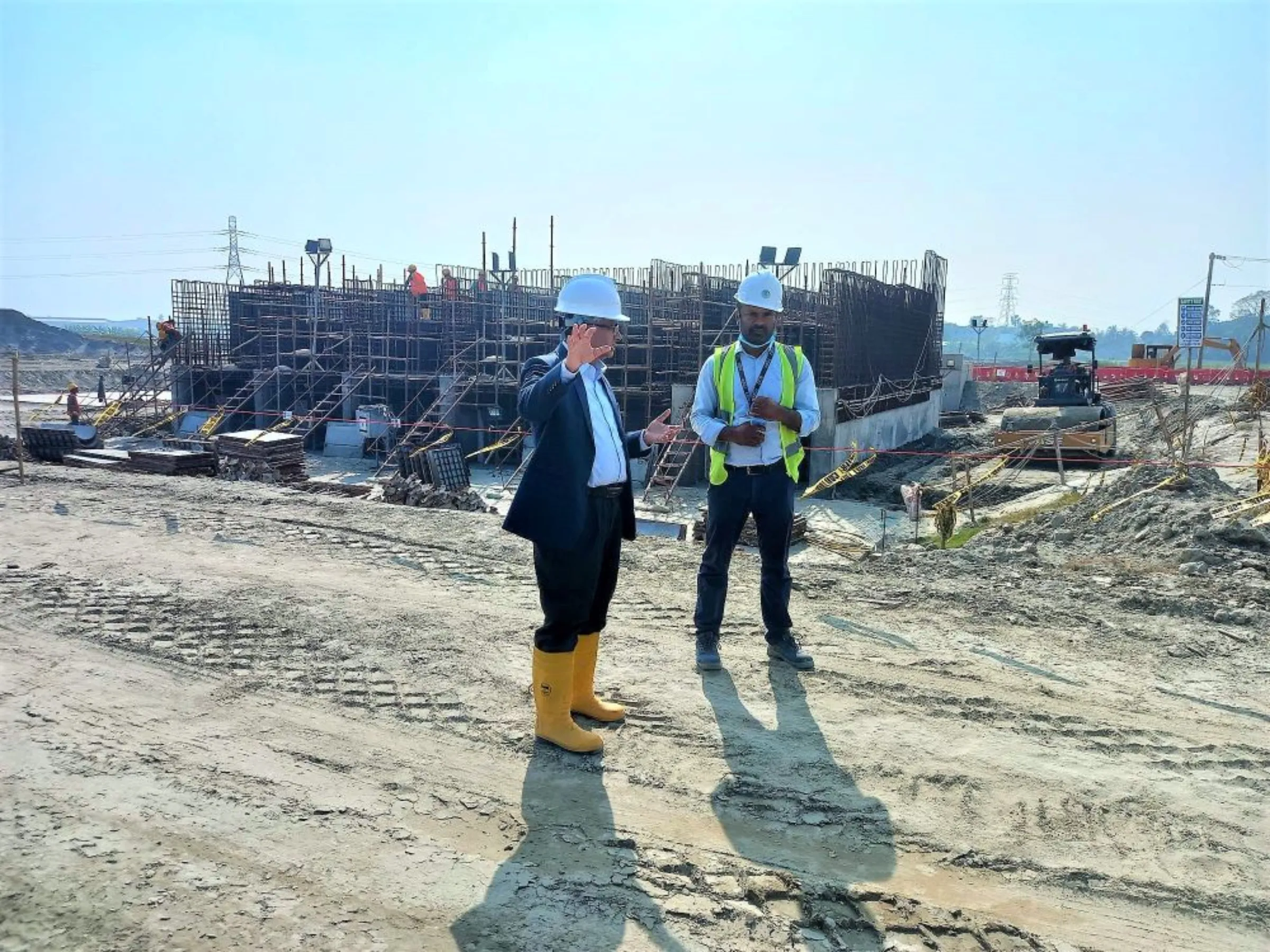 Saleh Ahmed, project director for the Japanese economic zone, talking to a technician at the construction site, Narayanganj, Bangladesh, January 11, 2023, Thomson Reuters Foundation/ Md. Tahmid Zami