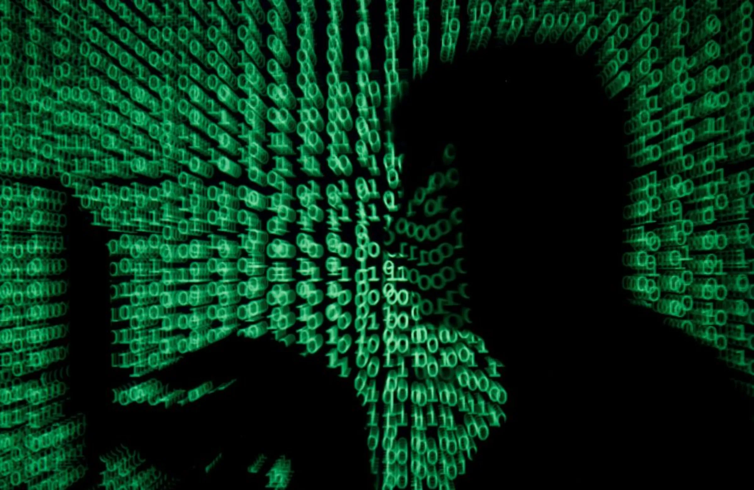 A man holds a laptop computer as cyber code is projected on him in this illustration picture taken on May 13, 2017
