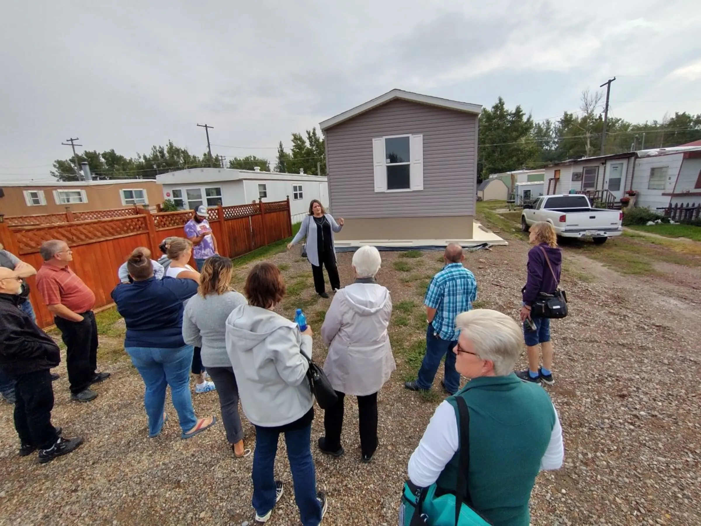 Residents and others view a new “infill” manufactured home placed out of flood risk at a mobile home community in Great Falls, Montana, in September 2022