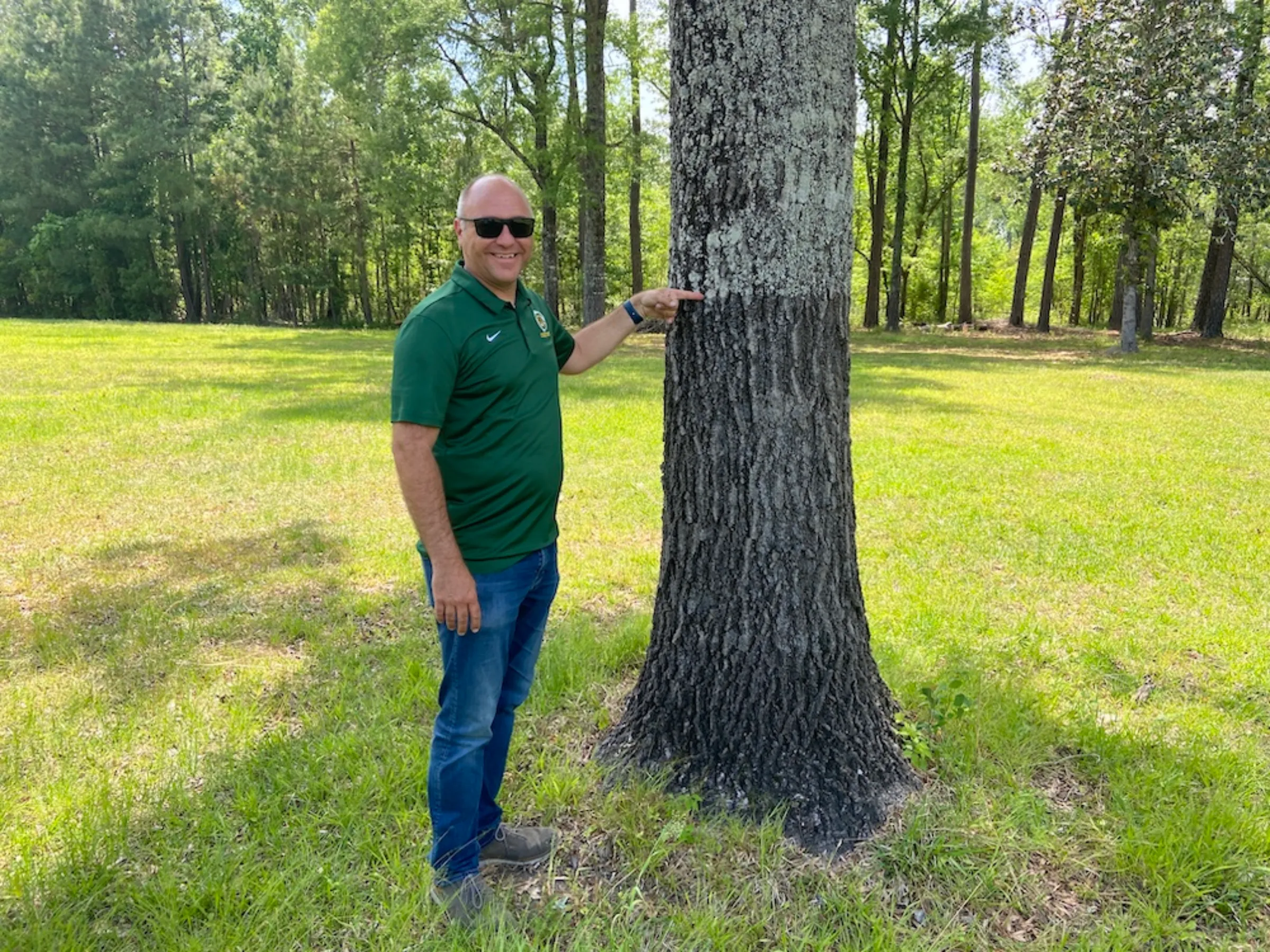 Adam Emrick, city administrator of Conway, South Carolina, points to a mark on a tree signifying the water level from a previous flood on Friday, May 6, 2022. Thomson Reuters Foundation/David Sherfinski