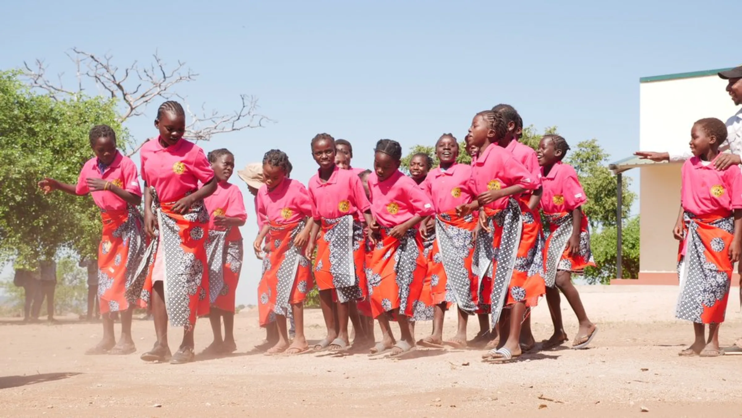 Young girls dance outside a classroom paid for by Gorongosa National Park in the buffer zone surrounding the park in Sofala province, Mozambique, May 24, 2022