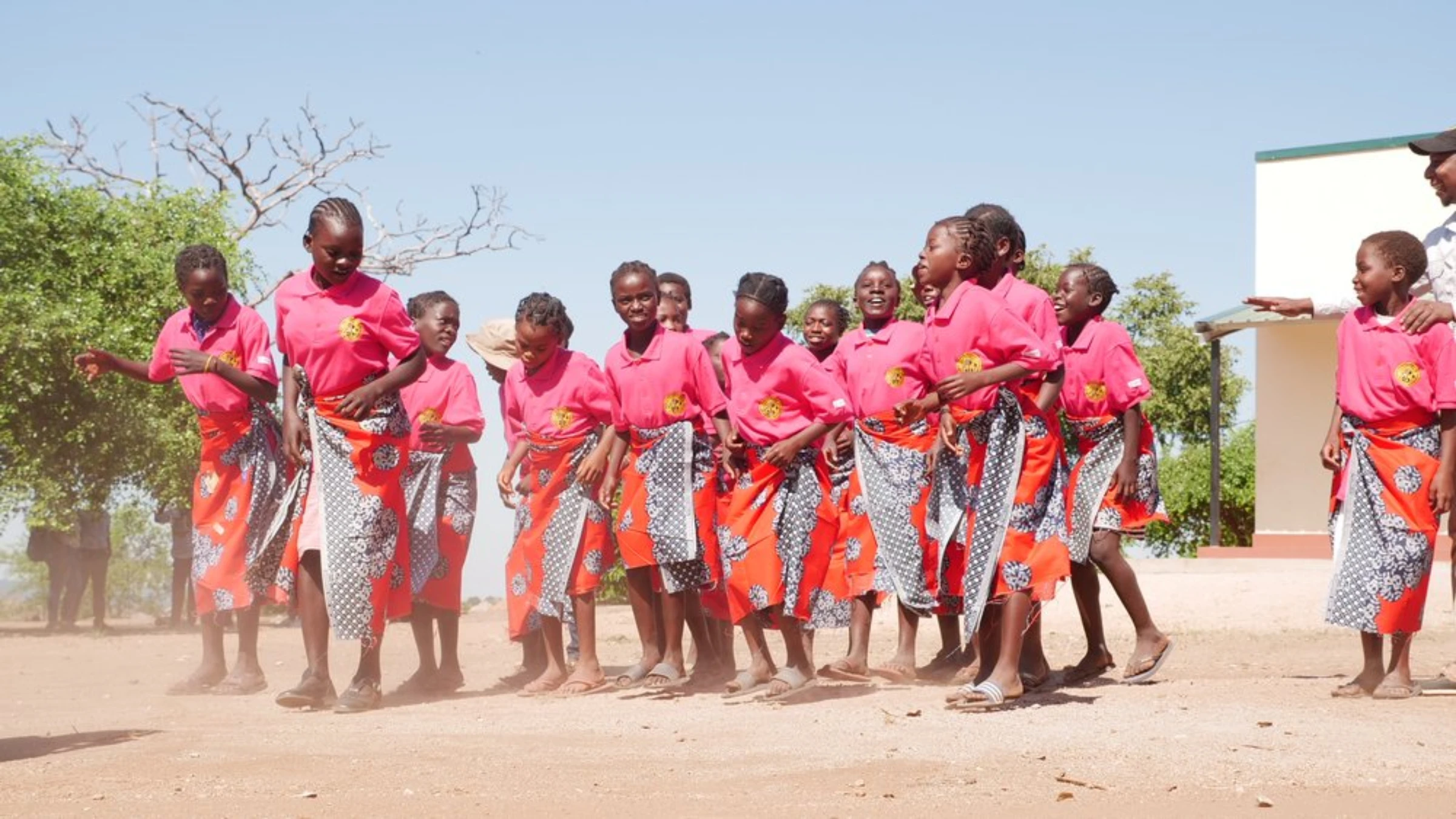 Young girls dance outside a classroom paid for by Gorongosa National Park in the buffer zone surrounding the park in Sofala province, Mozambique, May 24, 2022