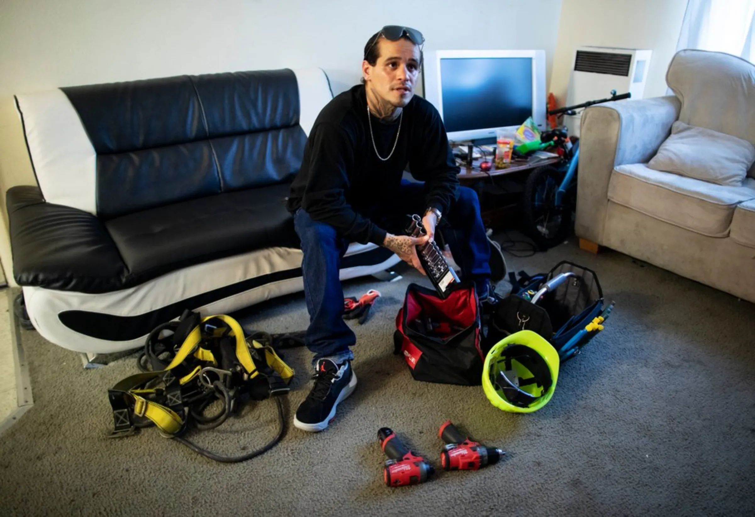 Ex-gang member Ramon Ramos displays the tools he uses to install solar panel systems at his mother’s apartment in North Hollywood, California, May 20, 2021