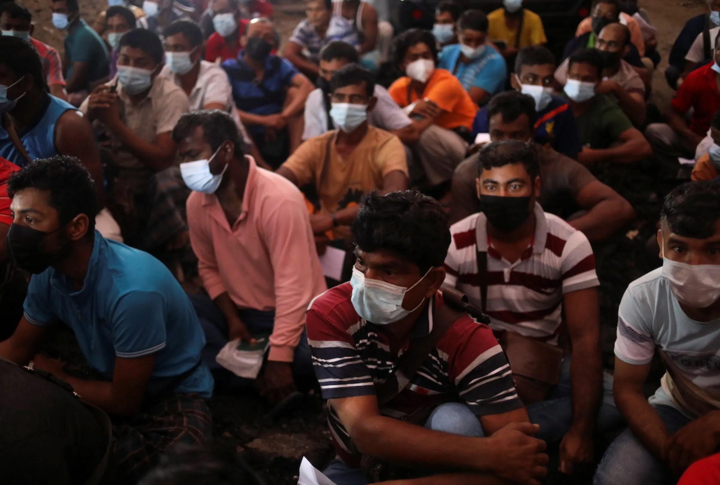 Migrant workers gather at the compound of their dormitory for a document check, during a joint operation by the Department of Labour and several other Malaysian government agencies on workers' living condition and other criteria of forced labour and human trafficking, in Kuala Lumpur, Malaysia, March 17, 2022. REUTERS/Hasnoor Hussain