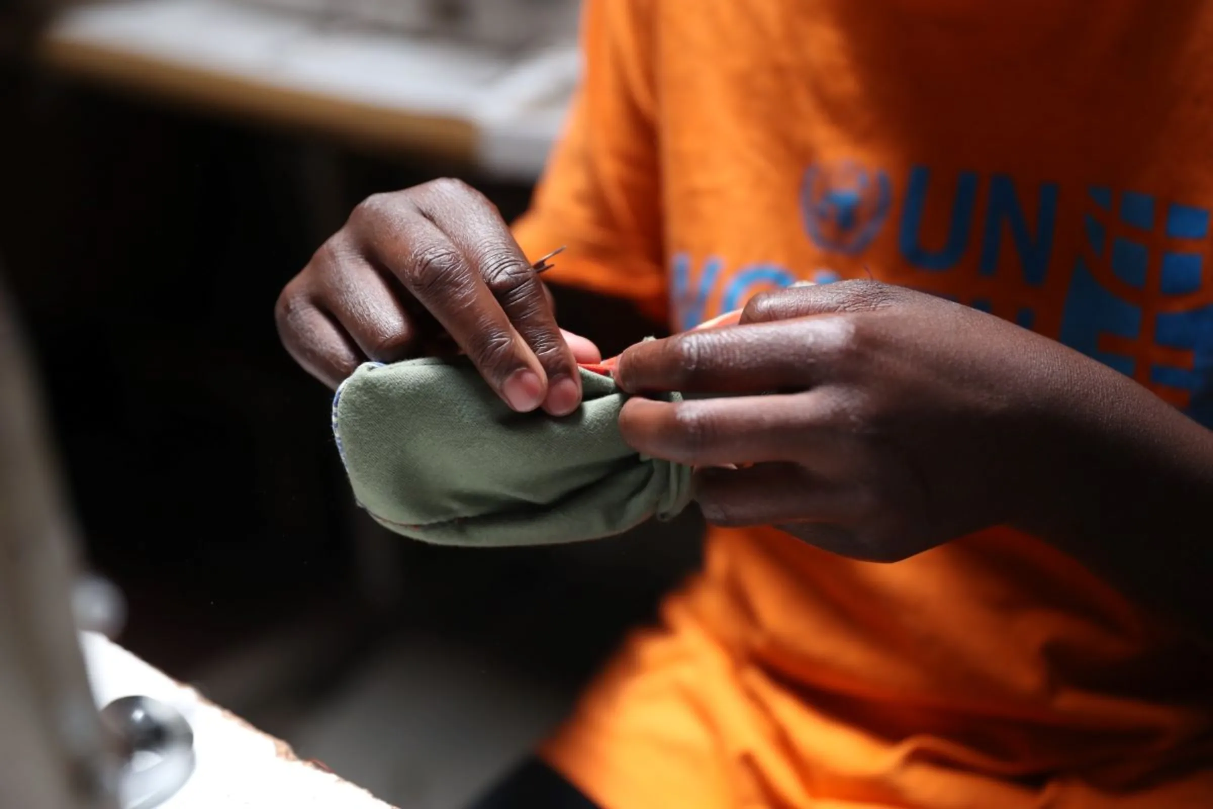 A woman stitches a reuseable cloth sanitary pad at charity Amani Kibera in Kibera informal settlement in Nairobi, Kenya on April 15, 2023