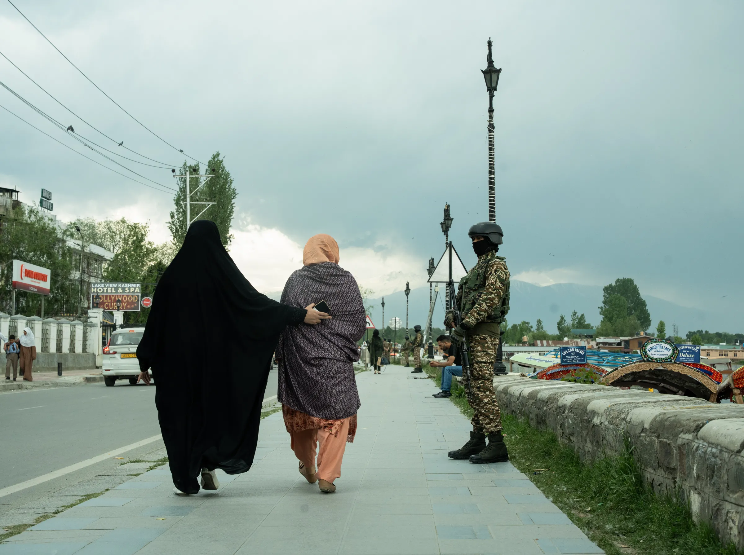 A Kashmiri girl walks with her mother past a government force on the banks of Dal Lake as security is heightened in the region. April 24, 2025. Mehran Firdous/Thomson Reuters Foundation
