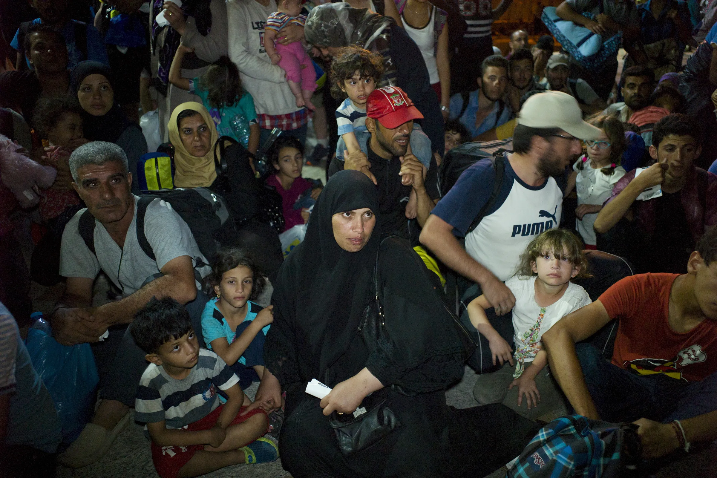Refugees and migrants wait to board a passenger ship, at the port on the island of Lesbos, Greece September 7, 2015. REUTERS/Dimitris Michalakis