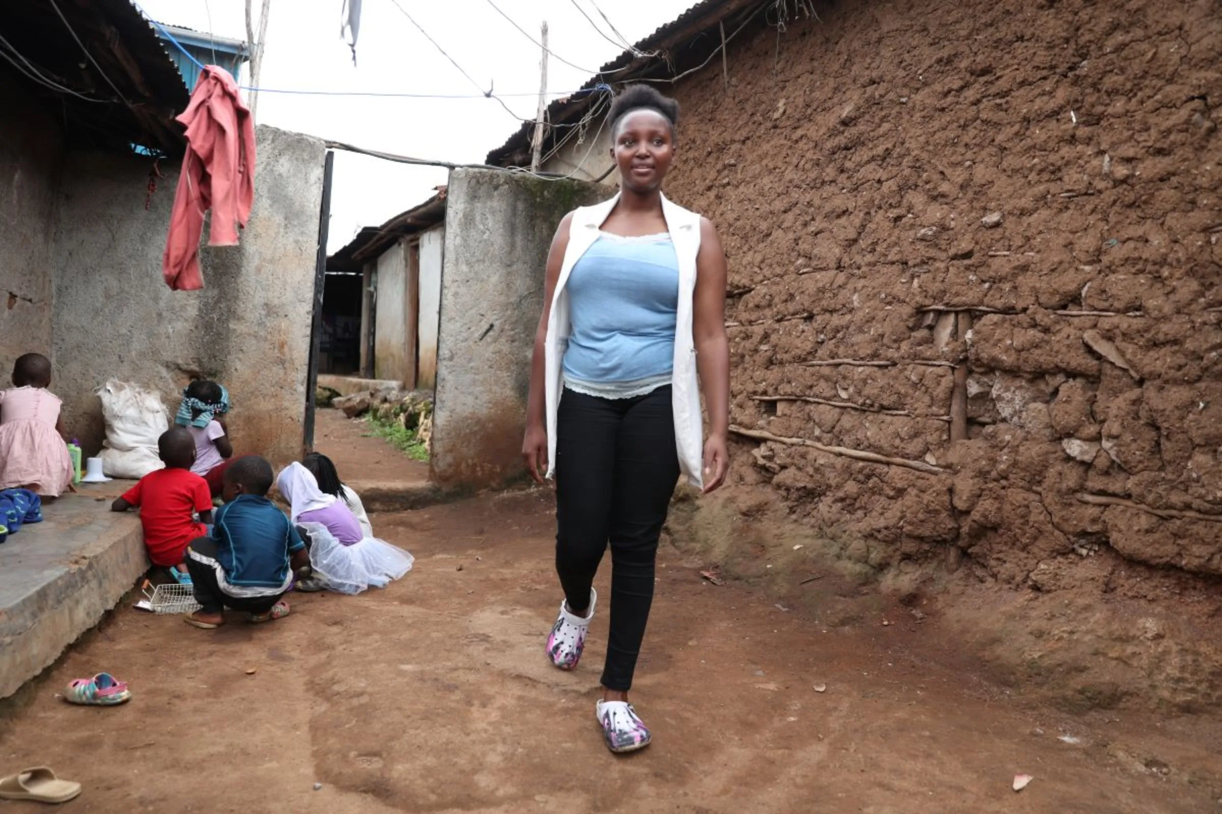 Lilian Makau, 20, walks in in Kibera informal settlement in Nairobi, Kenya on April 24, 2023. She said her story shows the need for more action to tackle period poverty