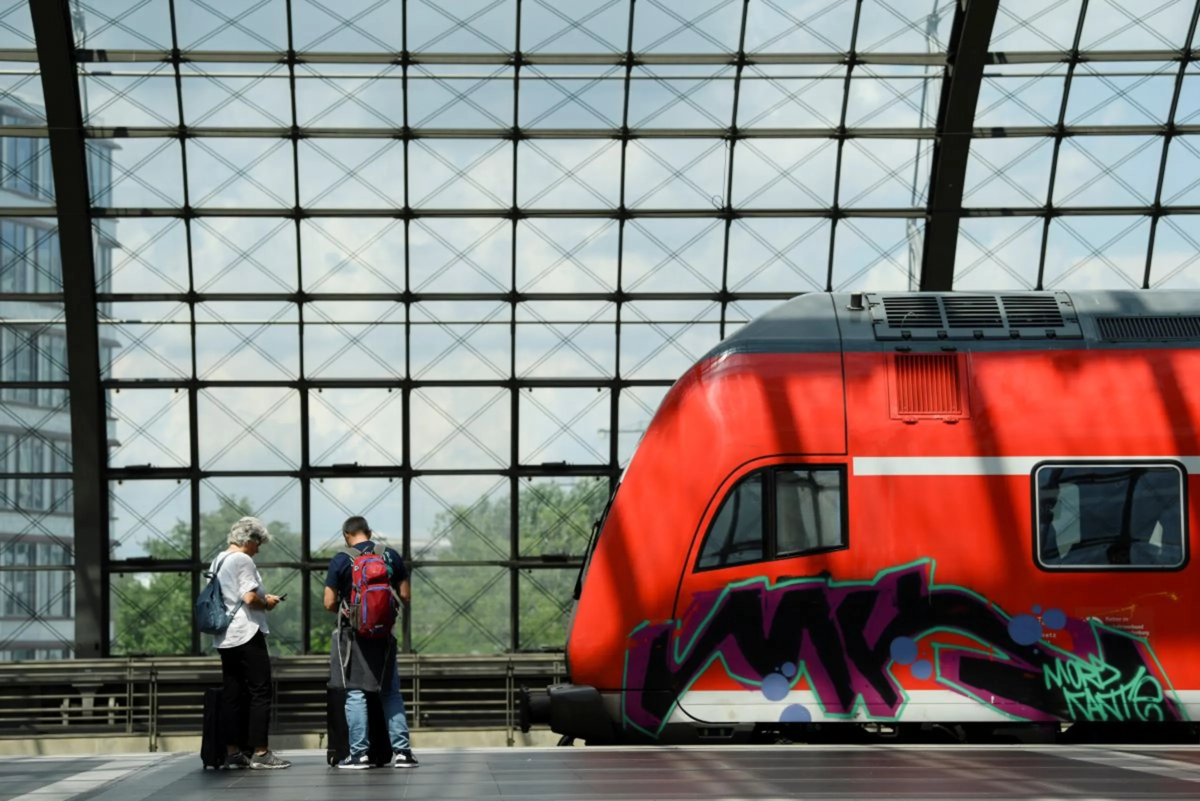 People stand on a platform as a regional train passes Berlin Central Station in Berlin, Germany June 1, 2022. REUTERS/Annegret Hilse