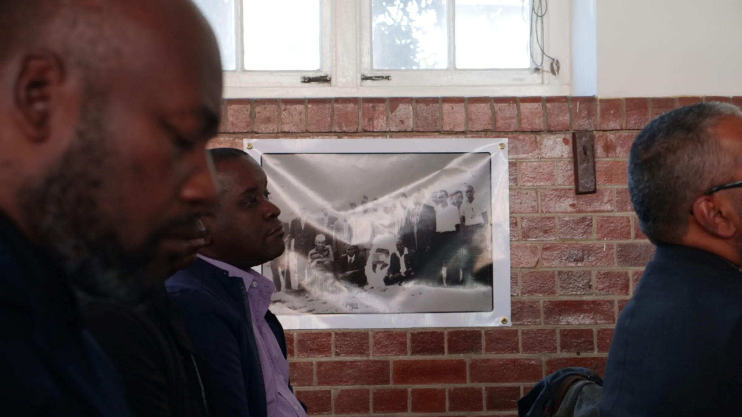 Attendees seated in front of an image of some of the first freed Amakua slaves brought to South Africa by the British, presented at a conference in Durban, South Africa, August 7, 2023