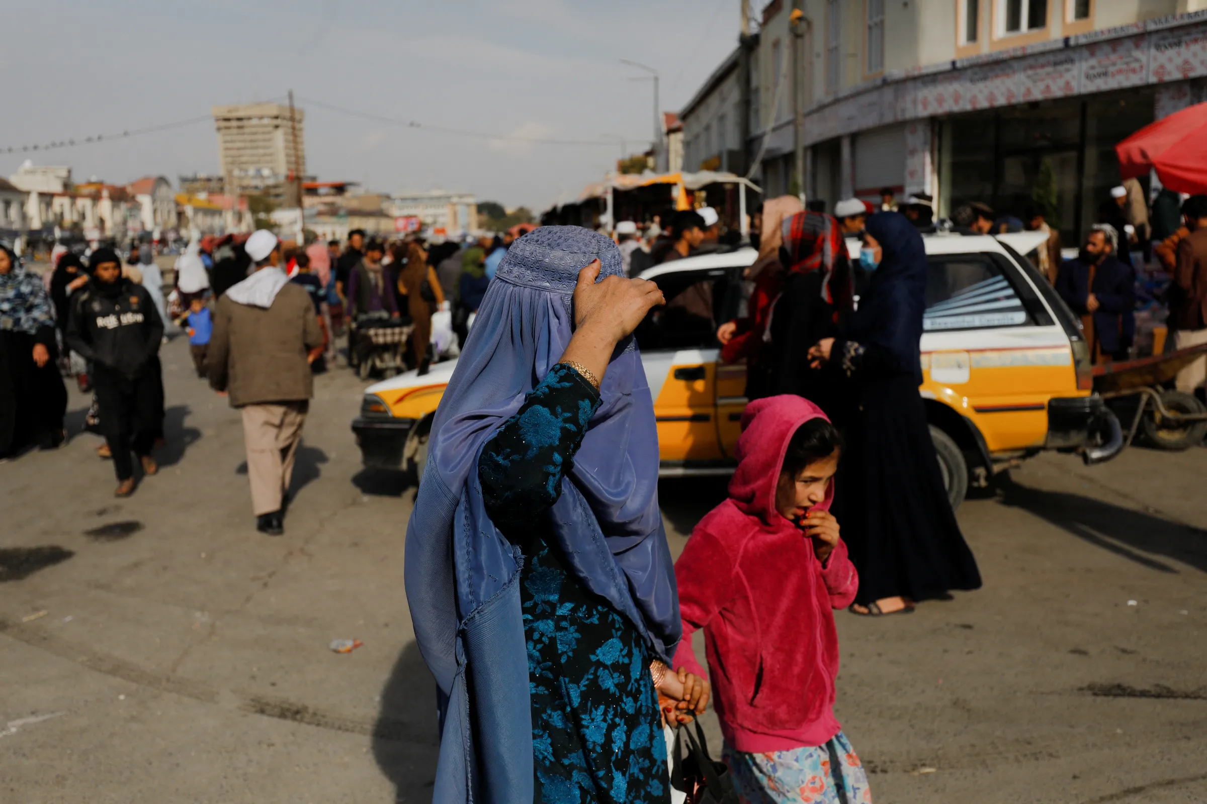 An Afghan woman and a girl walk in a street in Kabul, Afghanistan, November 9, 2022. REUTERS/Ali Khara